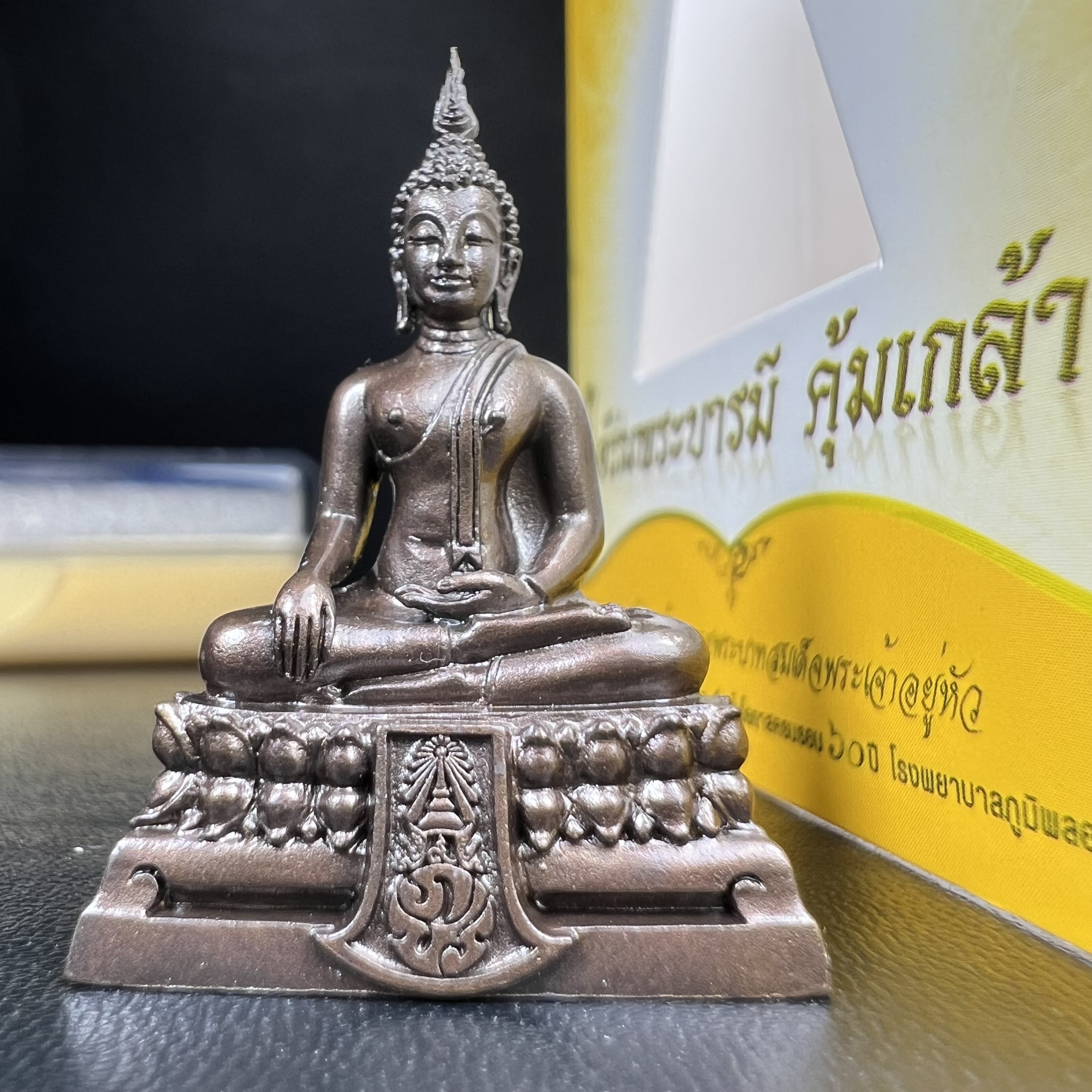 พระพุทธรูปคุ้มเกล้าฯ ภปร.(ใต้ร่มพระบารมี คุ้มเกล้า) 60ปี โรงพยาบาลภูมิพลฯ พ.ศ.2552 เนื้อนวโลหะ รมดำ(พิมพ์ใหญ่ขนาด 35.5*24 มม.)สภาพสวยเดิมพร้อมกล่องบรรจุเดิม ตอกโค๊ดหมายเลขกำกับ