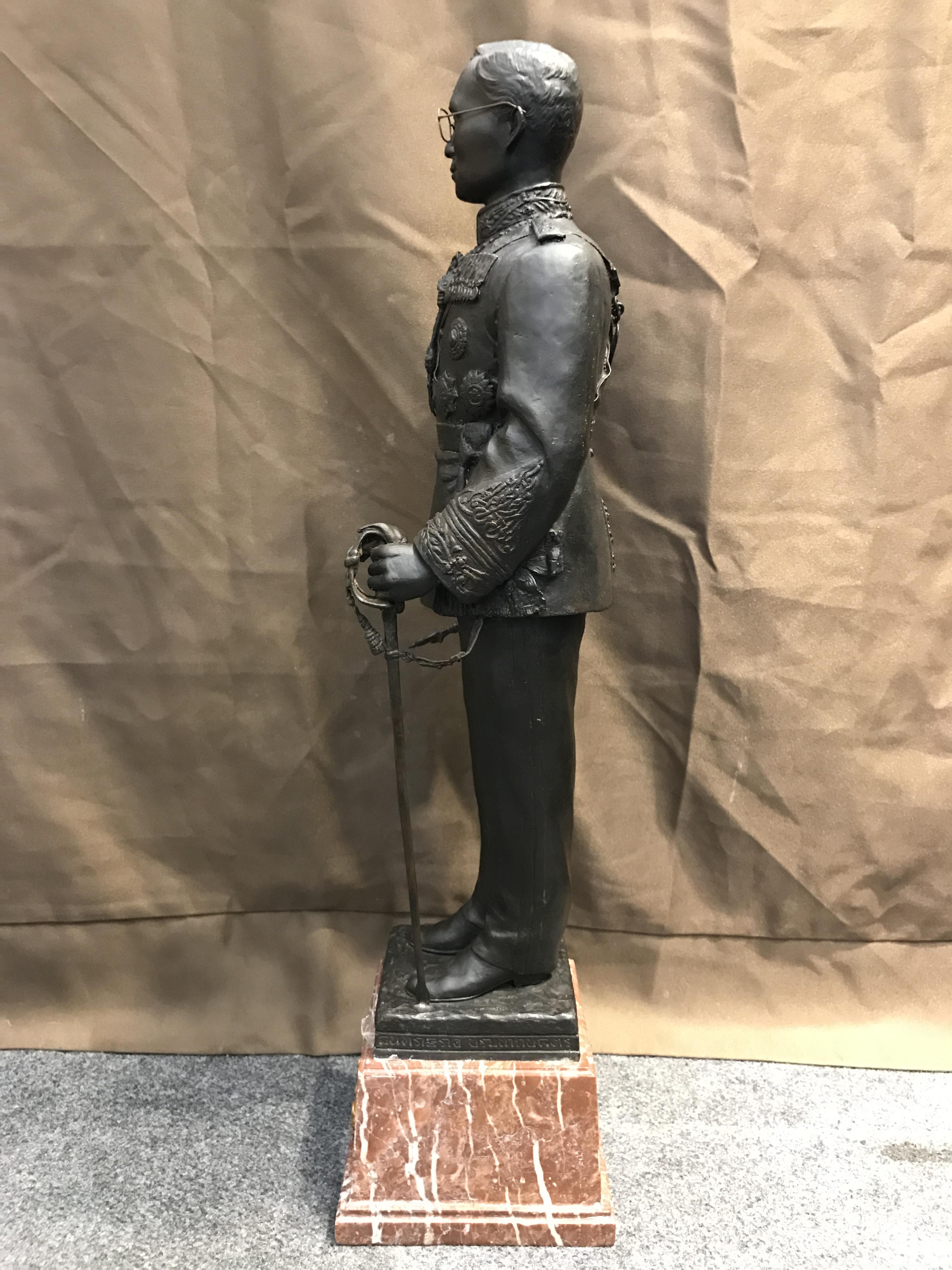 พระบรมรูปพระบาทสมเด็จพระเจ้าอยู่หัวรัชกาลที่9 เนื่องในวโรกาสที่ท่านเสด็จเถลิงถวัลย์ราชนสมบัติเป็นปีที่ 50 พุทธศักราช 2539 ( ปีกาญจนาภิเษก ) เนื้อสำริดนอก องค์ยืนบนฐานหินอ่อนพร้อมตราฉลองครองราชย์ ครบ50 ปี