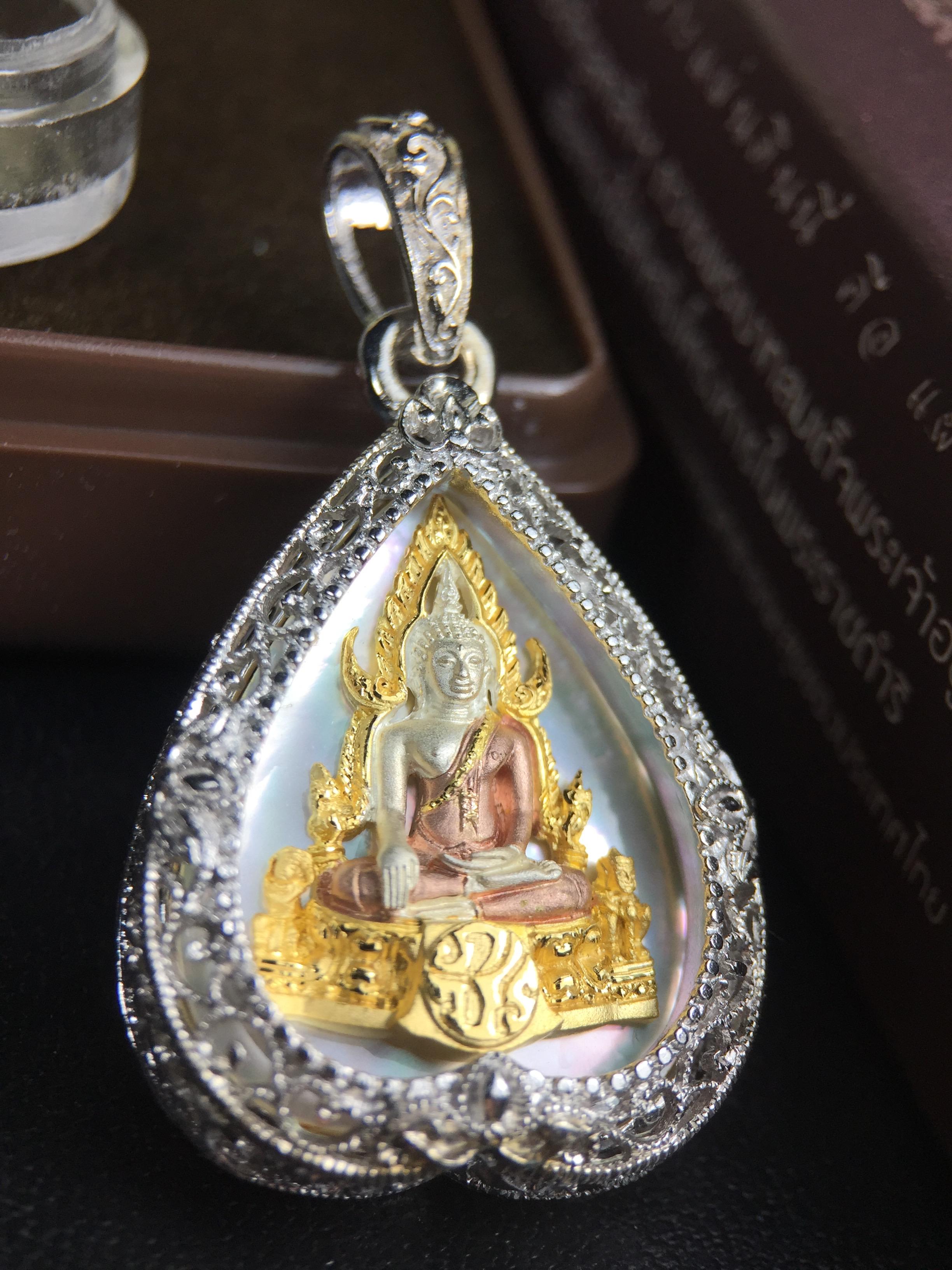 พระพุทธชินราช ภปร. โครงการ "เพราะแผ่นดินนี้ คือ แผ่นดินเกิด" ปี2548(รุ่นแรก) เหรียญทรงใบโพธิ์ ขนาด 21 x 29 มม. เนื้อเงินสามกษัตริย์ องค์พระชุบสามกษัตริย์ ล้อมด้วยกรอบเงินชุบทองคำขาวสลักเสลาเป็นลวดลายละเอียดอ่อน ส่วนพื้นองค์พระเป็นเปลือกหอยมุข