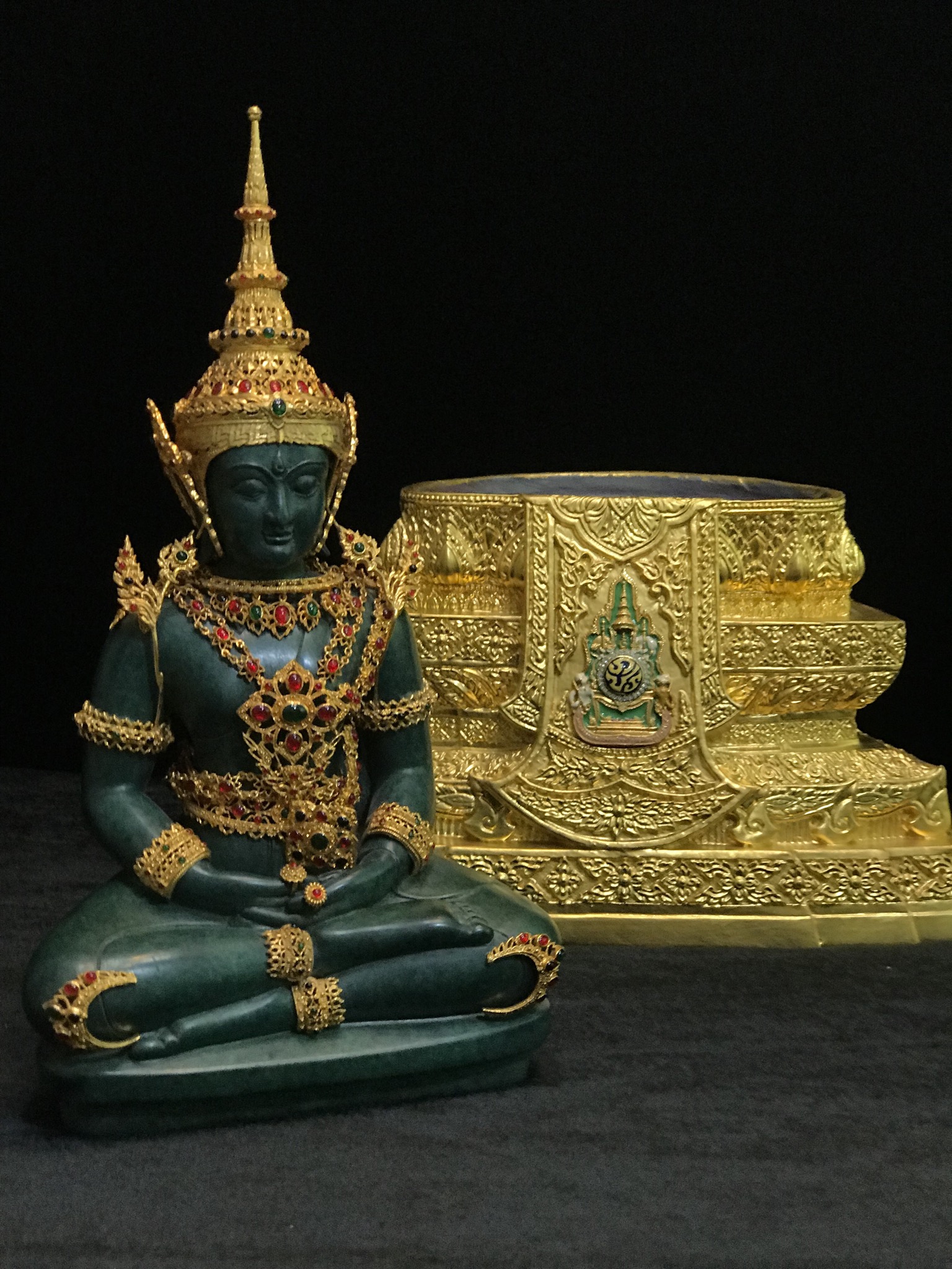 พระแก้วมรกต(จำลอง)ลอยองค์ ขนาดหน้าตัก 5 นิ้ว ทรงเครื่องฤดูร้อน เนื้อโลหะเคลือบสีเขียว เครื่องทรงชุบทองลงยาสี ฐานเนื้อโลหะ ลงรักปิดทองคำ ประดิษฐานตราสัญลักษณ์ฉลองสิริราชสมบัติ ครบ 60 ปี