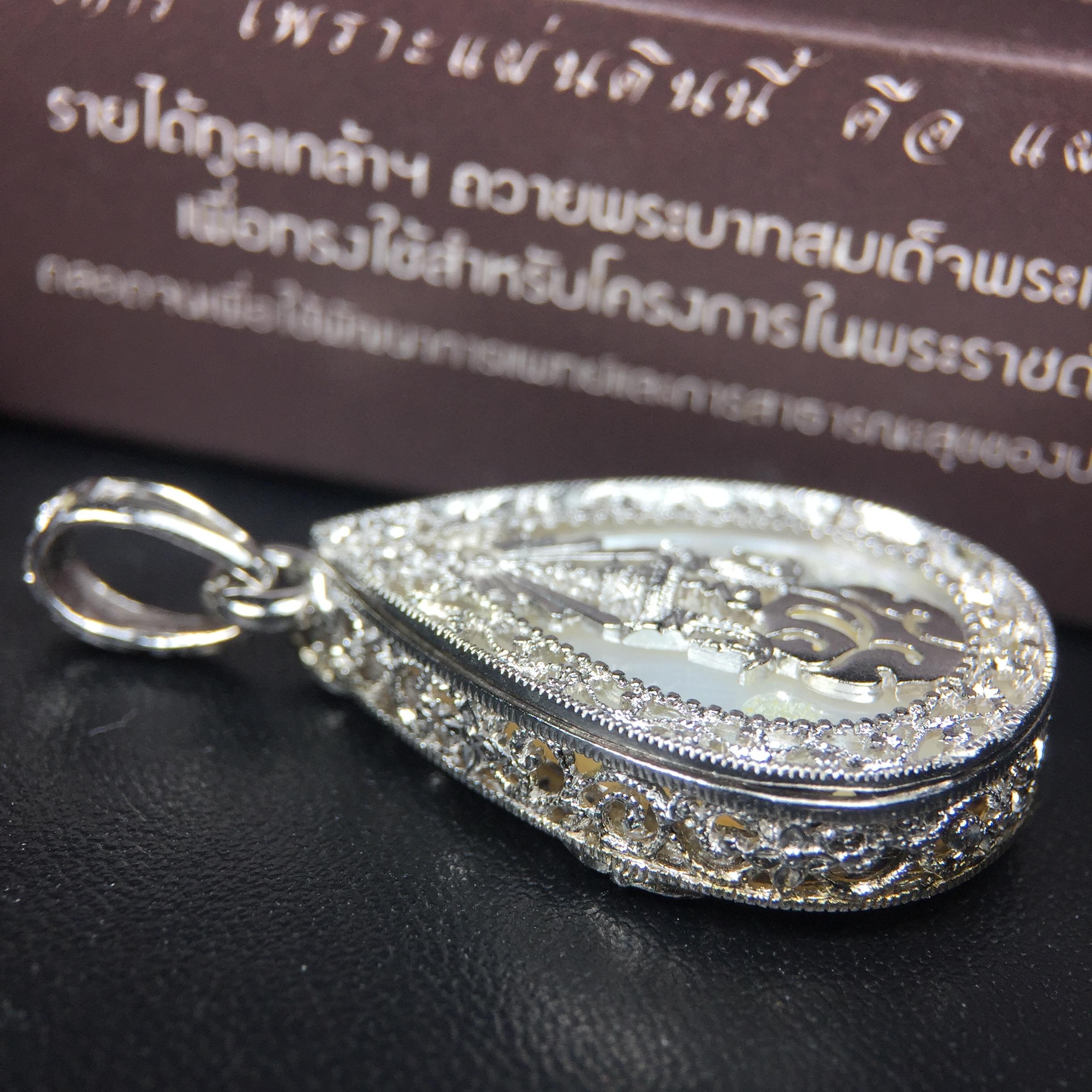 พระพุทธชินราช ภปร. โครงการ "เพราะแผ่นดินนี้ คือ แผ่นดินเกิด" ปี2548(รุ่นแรก) เหรียญทรงหยดน้ำ ขนาด 21 x 31 มม. เนื้อเงินสามกษัตริย์ องค์พระชุบสามกษัตริย์ ล้อมด้วยกรอบเงินชุบทองคำขาวสลักเสลาเป็นลวดลายละเอียดอ่อน ส่วนพื้นองค์พระเป็นเปลือกหอยมุข