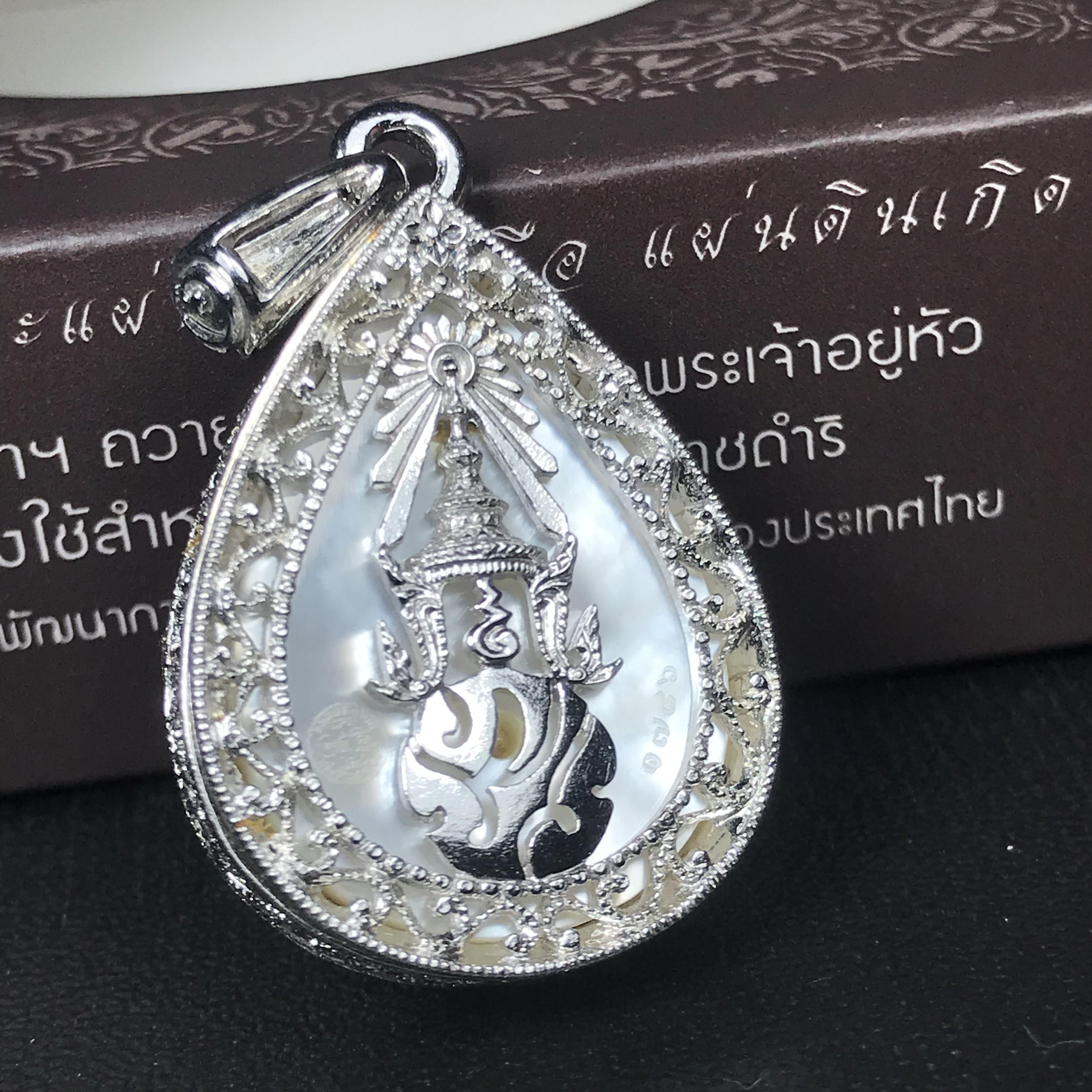 พระพุทธชินราช ภปร. โครงการ "เพราะแผ่นดินนี้ คือ แผ่นดินเกิด" ปี2548(รุ่นแรก) เหรียญทรงหยดน้ำ ขนาด 21 x 31 มม. เนื้อเงินสามกษัตริย์ องค์พระชุบสามกษัตริย์ ล้อมด้วยกรอบเงินชุบทองคำขาวสลักเสลาเป็นลวดลายละเอียดอ่อน ส่วนพื้นองค์พระเป็นเปลือกหอยมุข