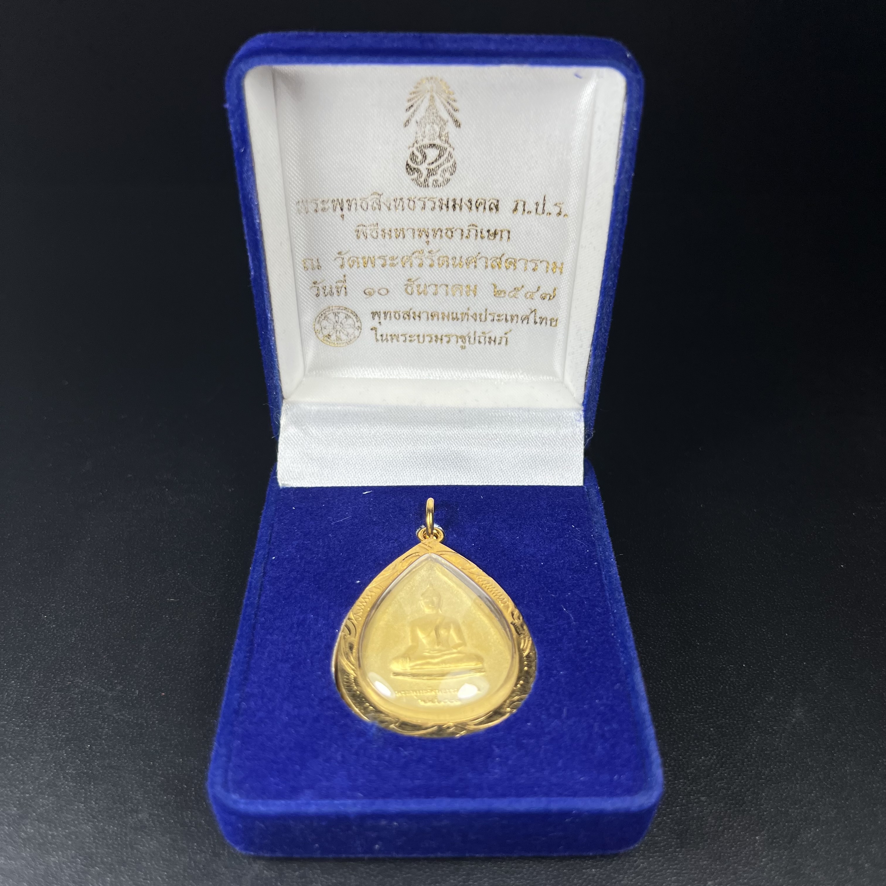 เหรียญพระพุทธสิงหธรรมมงคล ภปร. ปี 2547 ทรงหยดน้ำ ด้านหลังมี ภ.ป.ร. (ชนวนเก่า)เนื้อโลหะผสม ชุบทองพ่นทราย สูง 3.3ซม.พิธีใหญ่ มวลสารดี ปลุกเสกวัดพระแก้ว(งานเลี่ยมกรอบเดิมจากผู้จัดสร้างห่อหุ้มด้วยทองนพเกล้า)