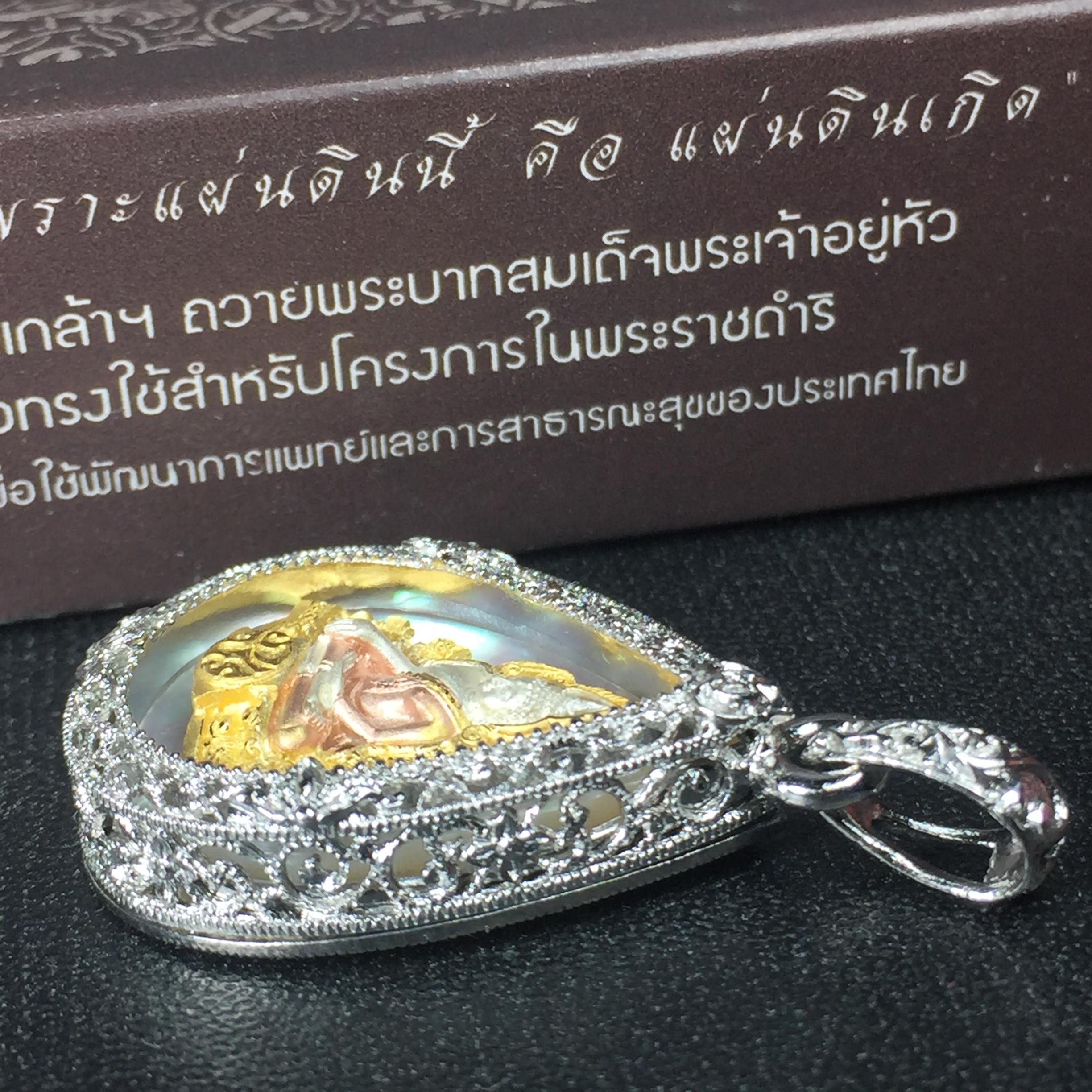 พระพุทธชินราช ภปร. โครงการ "เพราะแผ่นดินนี้ คือ แผ่นดินเกิด" ปี2548(รุ่นแรก) เหรียญทรงหยดน้ำ ขนาด 21 x 31 มม. เนื้อเงินสามกษัตริย์ องค์พระชุบสามกษัตริย์ ล้อมด้วยกรอบเงินชุบทองคำขาวสลักเสลาเป็นลวดลายละเอียดอ่อน ส่วนพื้นองค์พระเป็นเปลือกหอยมุข