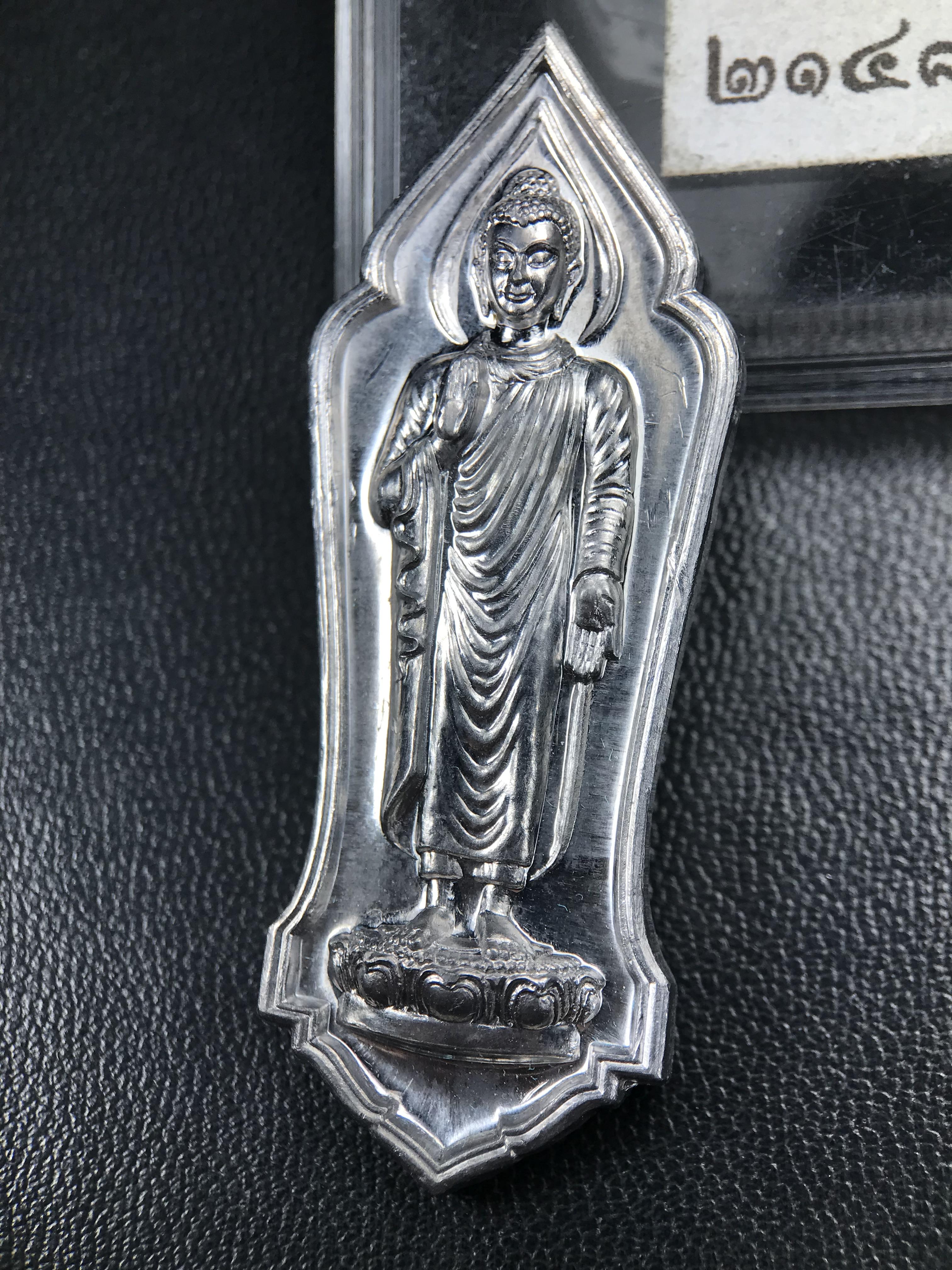 เหรียญที่ระลึกพระพุทธเมตตาประชาไทยไตรโลกนาถคันธารราฐอนุสรณ์ หลัง ภปร. และ สก. วัดทิพย์สุคนธาราม จ.กาญจนบุรี ปี 2558 เนื้อชิน(ตะกั่ว) ขนาดสูง 4.6 ซม. ที่ระลึก ร.9 พระชนมพรรษาครบ 7 รอบ และ สมเด็จพระราชินี พระชนมพรรษา 80 พรรษา พิธีใหญ่