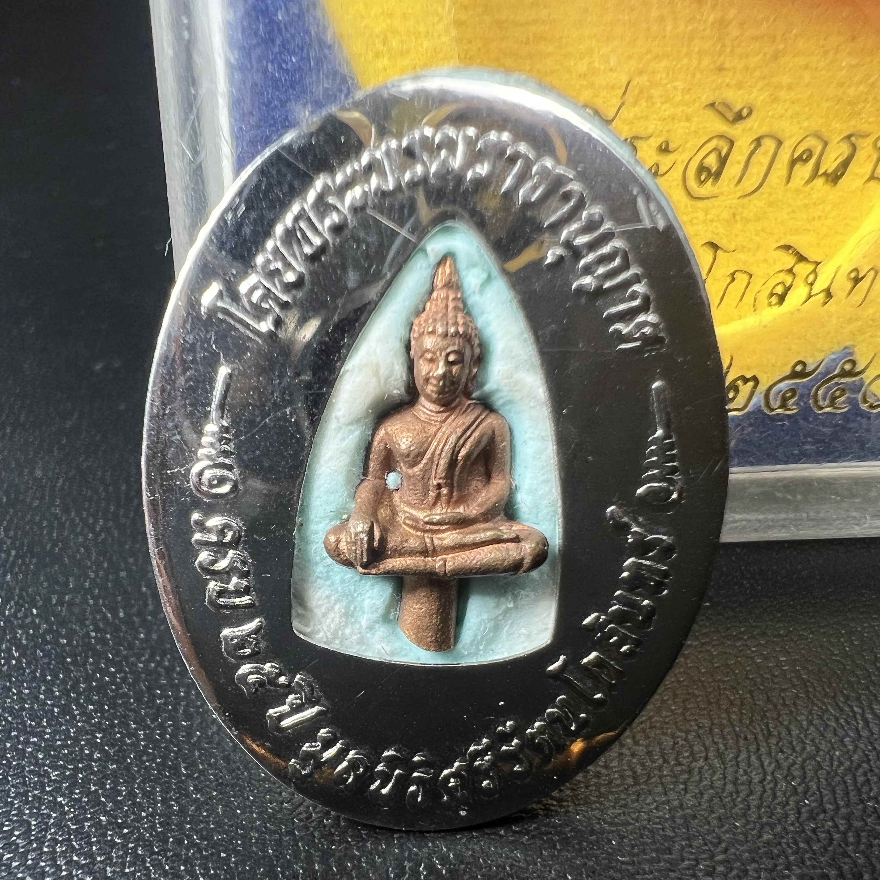 ล็อกเกตในหลวงรัชกาลที่9 ที่ระลึกครบ 25 ปี มูลนิธิศรีรัตนโกสินทร์ วัดสุทธาราม พ.ศ. 2550 พิมพ์ทรงวงรีรูปไข่เล็กฉากสีทอง หลังปิดแผ่นโลหะสีขาว(สแตนเลส)ฝังพระยอดธง(นิยม)