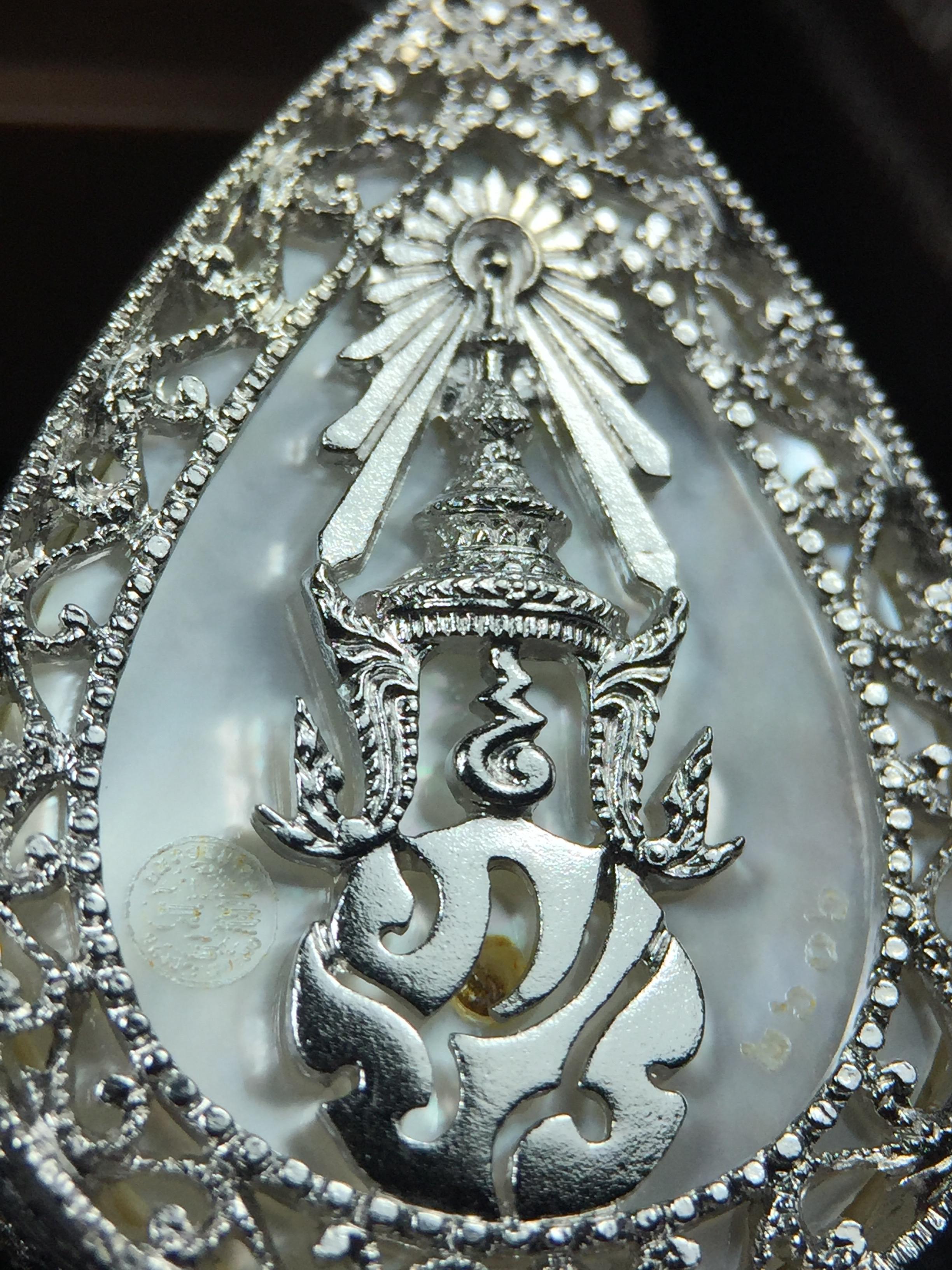 พระพุทธชินราช ภปร. โครงการ "เพราะแผ่นดินนี้ คือ แผ่นดินเกิด" ปี2548(รุ่นแรก) เหรียญทรงหยดน้ำ ขนาด 21 x 31 มม. เนื้อเงินสามกษัตริย์ องค์พระชุบสามกษัตริย์ ล้อมด้วยกรอบเงินชุบทองคำขาวสลักเสลาเป็นลวดลายละเอียดอ่อน ส่วนพื้นองค์พระเป็นเปลือกหอยมุข