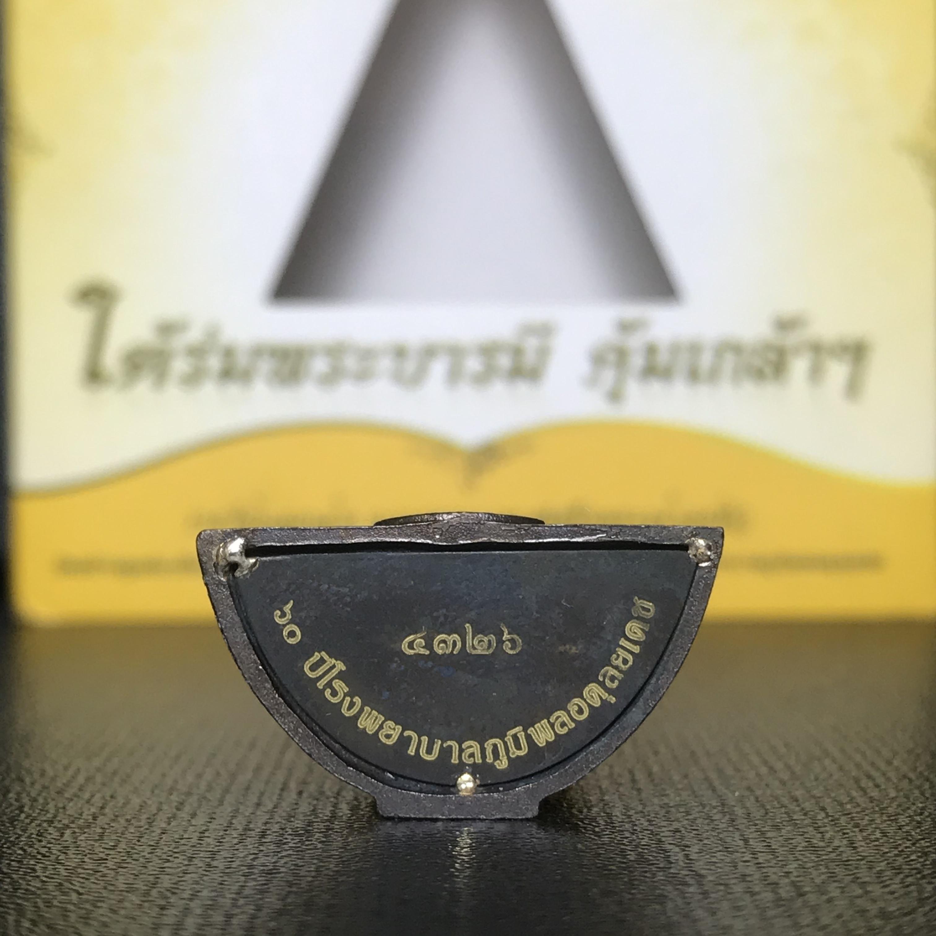 พระพุทธรูปคุ้มเกล้าฯ ภปร.(ใต้ร่มพระบารมี คุ้มเกล้า) 60ปี รพ.ภูมิพลฯ พ.ศ.2552 เนื้อนวโลหะ รมดำ(พิมพ์ใหญ่ขนาด 35.5*24 มม.)