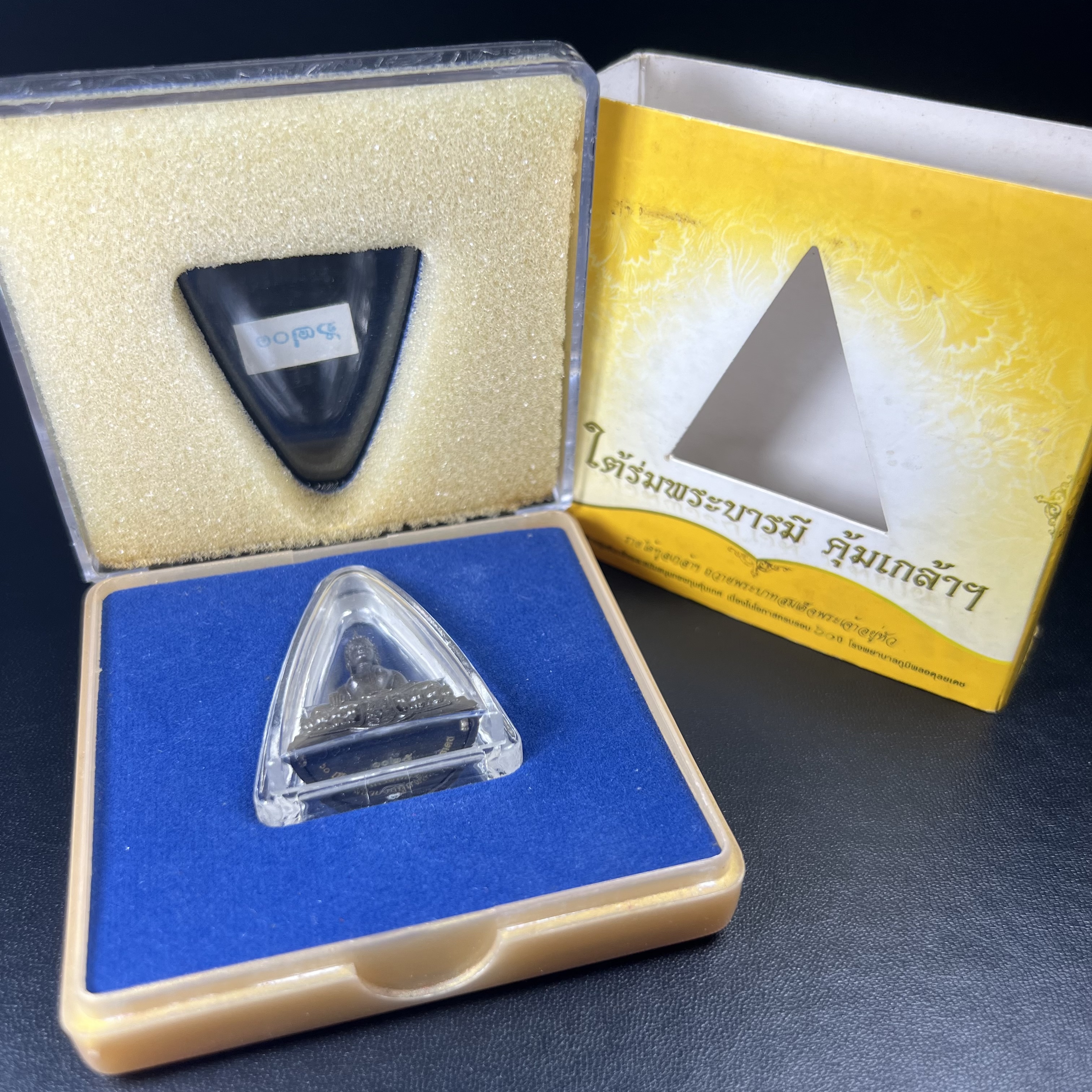 พระพุทธรูปคุ้มเกล้าฯ ภปร.(ใต้ร่มพระบารมี คุ้มเกล้า) 60ปี รพ.ภูมิพลฯ พ.ศ.2552 เนื้อนวโลหะ รมดำ(พิมพ์ใหญ่ขนาด 35.5*24 มม.)