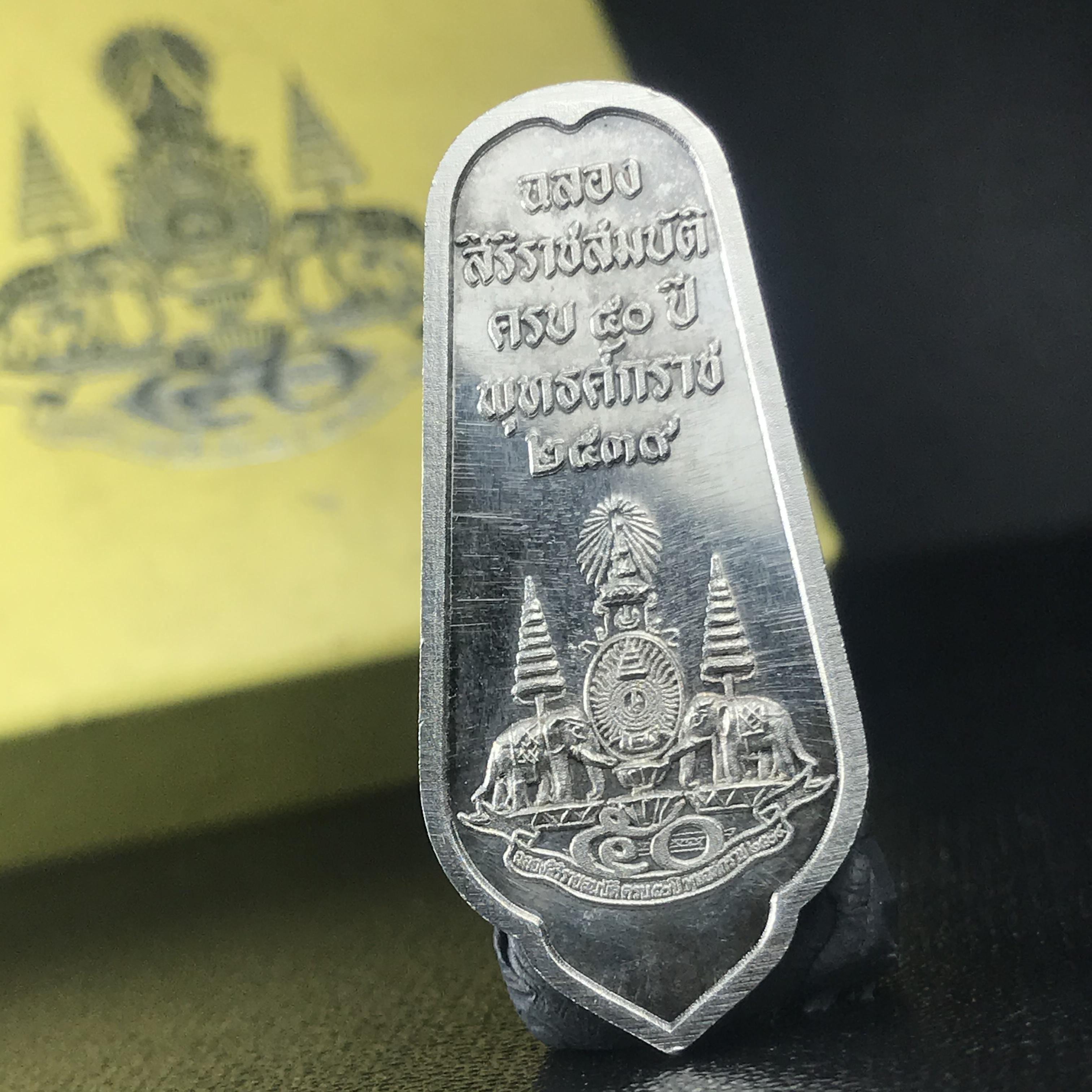 เหรียญพระพุทธอภัยมงคลสมังคี เนื้อเงิน สร้างเนื่องในมงคลโอกาสที่พระบาทสมเด็จพระเจ้าอยู่หัว ทรงครองสิริราชสมบัติครบ ๕๐ ปี พ.ศ.๒๕๓๙ ด้านหลังประดิษฐานตราสัญลักษณ์งานฉลองสิริราชสมบัติครบ ๕๐ ปี