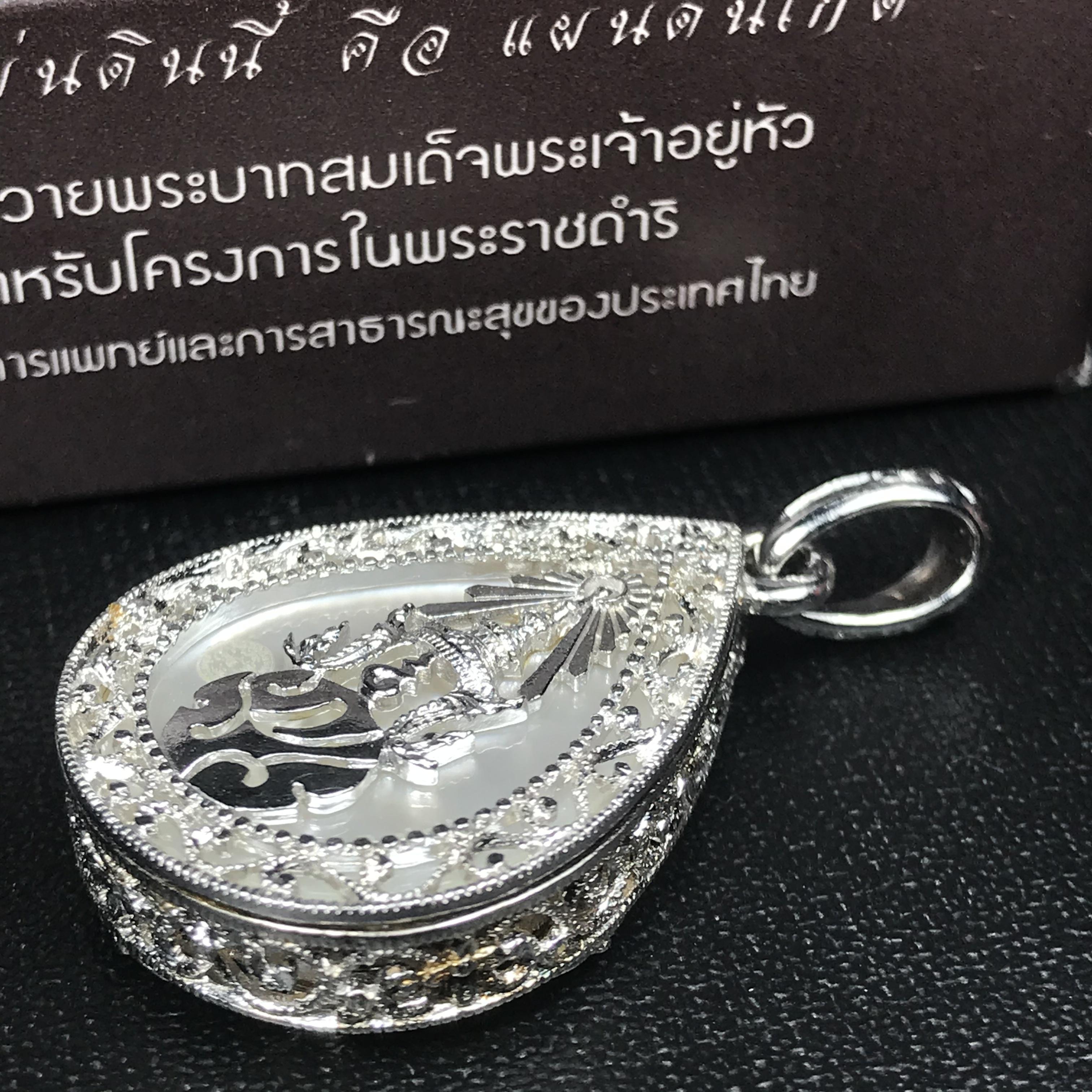 พระพุทธชินราช ภปร. โครงการ "เพราะแผ่นดินนี้ คือ แผ่นดินเกิด" ปี2548(รุ่นแรก) เหรียญทรงหยดน้ำ ขนาด 21 x 31 มม. เนื้อเงินสามกษัตริย์ องค์พระชุบสามกษัตริย์ ล้อมด้วยกรอบเงินชุบทองคำขาวสลักเสลาเป็นลวดลายละเอียดอ่อน ส่วนพื้นองค์พระเป็นเปลือกหอยมุข