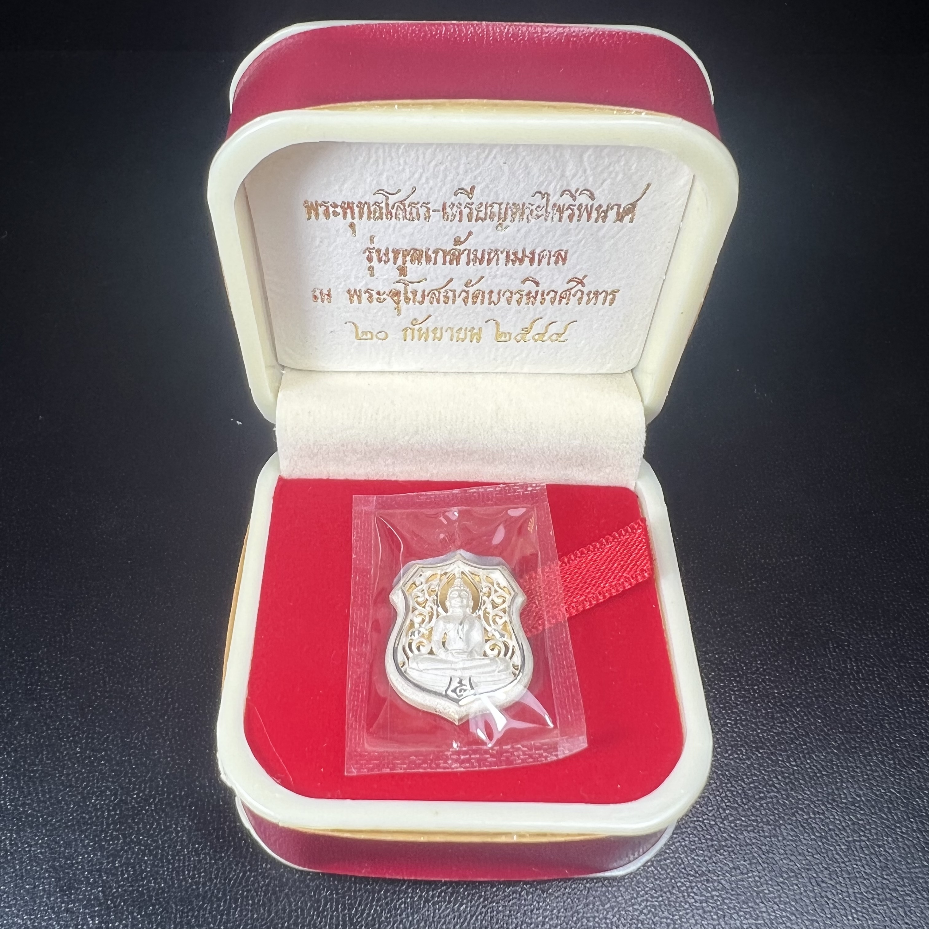 เหรียญหล่อฉลุลายพระพุทธโสธรทรงอาร์มลายกนก เนื้อเงินบริสุทธิ์พ่นทรายนวลขัดเงา(แผ่นกลางทองคำ) พิมพ์เล็ก สูง 2.1 ซม. รุ่น "ทูลเกล้ามหามงคล" ปี 2544(สภาพคัดสวยซีนซองเดิมกล่องบรรจุเดิมครบสมบูรณ์)