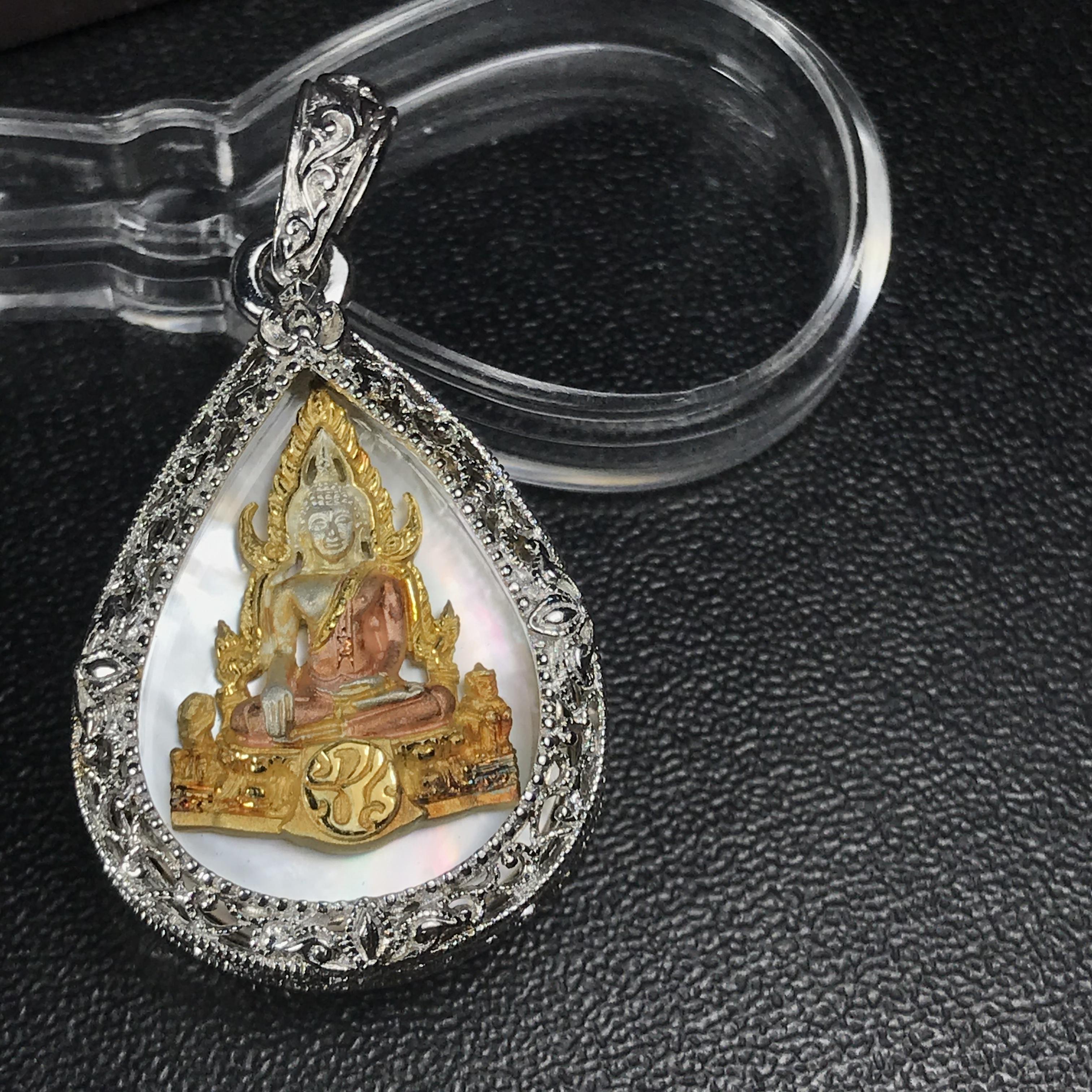 พระพุทธชินราช ภปร. โครงการ "เพราะแผ่นดินนี้ คือ แผ่นดินเกิด" ปี2548(รุ่นแรก) เหรียญทรงหยดน้ำ ขนาด 21 x 31 มม. เนื้อเงินสามกษัตริย์ องค์พระชุบสามกษัตริย์ ล้อมด้วยกรอบเงินชุบทองคำขาวสลักเสลาเป็นลวดลายละเอียดอ่อน ส่วนพื้นองค์พระเป็นเปลือกหอยมุข