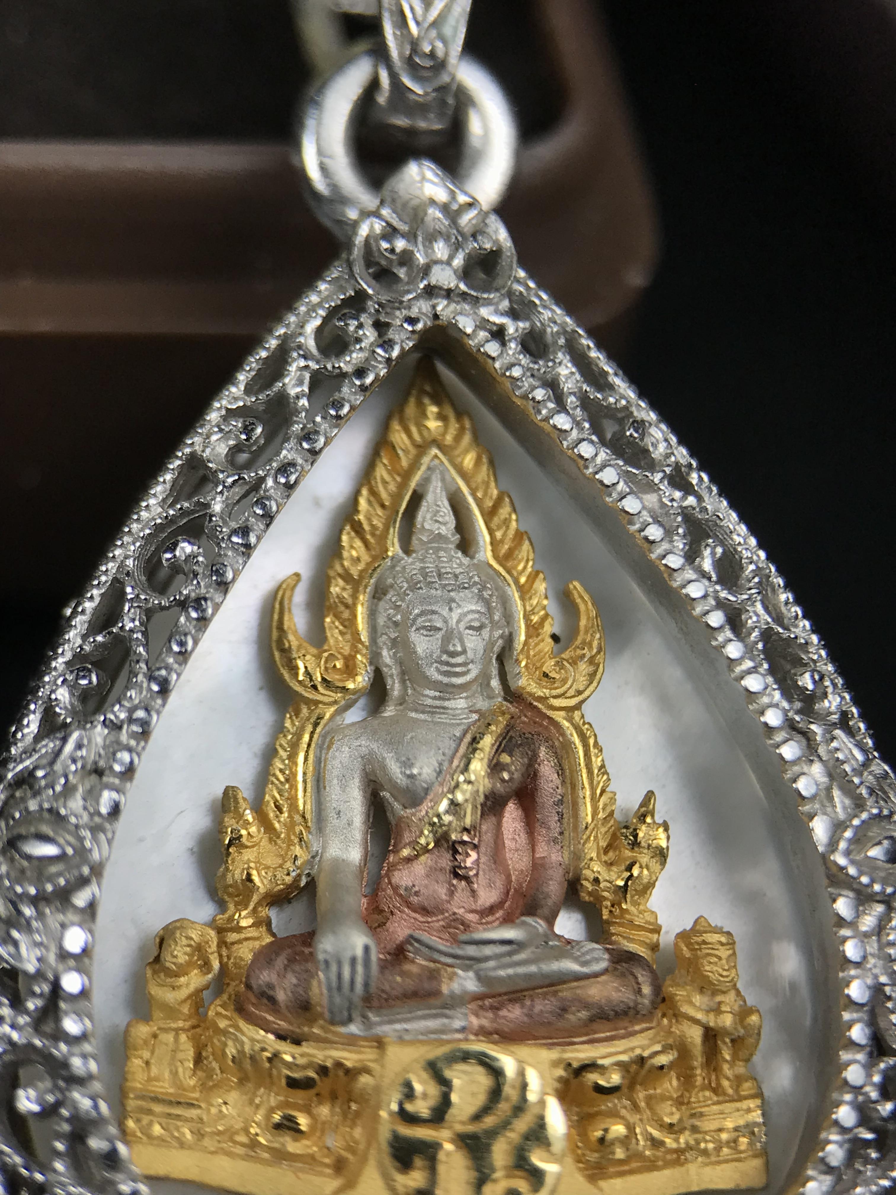 พระพุทธชินราช ภปร. โครงการ "เพราะแผ่นดินนี้ คือ แผ่นดินเกิด" ปี 2548(รุ่นแรก) เหรียญทรงใบโพธิ์ ขนาด 21 x 29 มม. เนื้อเงินสามกษัตริย์ องค์พระชุบสามกษัตริย์ ล้อมด้วยกรอบเงินชุบทองคำขาวสลักเสลาเป็นลวดลายละเอียดอ่อน ส่วนพื้นองค์พระเป็นเปลือกหอยมุข