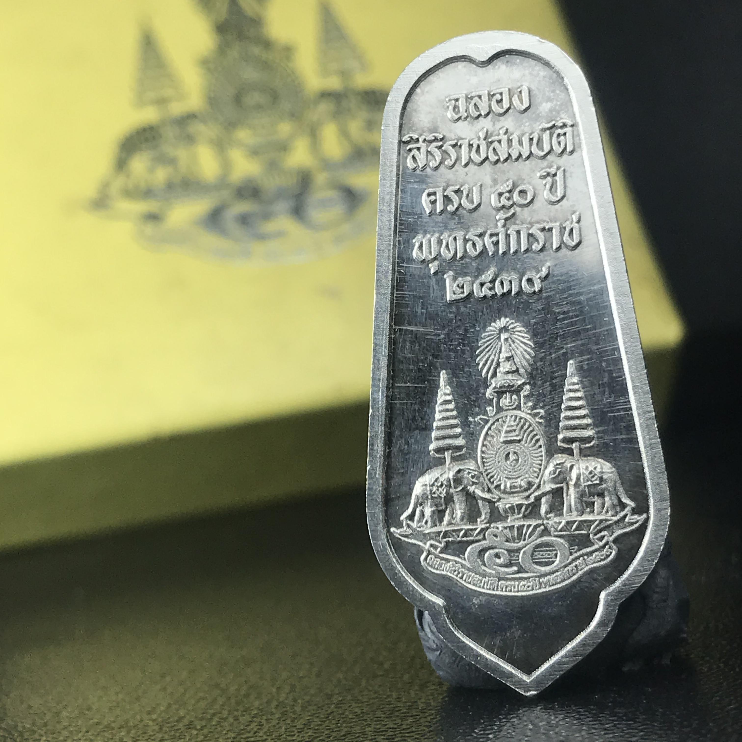 เหรียญพระพุทธอภัยมงคลสมังคี เนื้อเงิน สร้างเนื่องในมงคลโอกาสที่พระบาทสมเด็จพระเจ้าอยู่หัว ทรงครองสิริราชสมบัติครบ ๕๐ ปี พ.ศ.๒๕๓๙ ด้านหลังประดิษฐานตราสัญลักษณ์งานฉลองสิริราชสมบัติครบ ๕๐ ปี