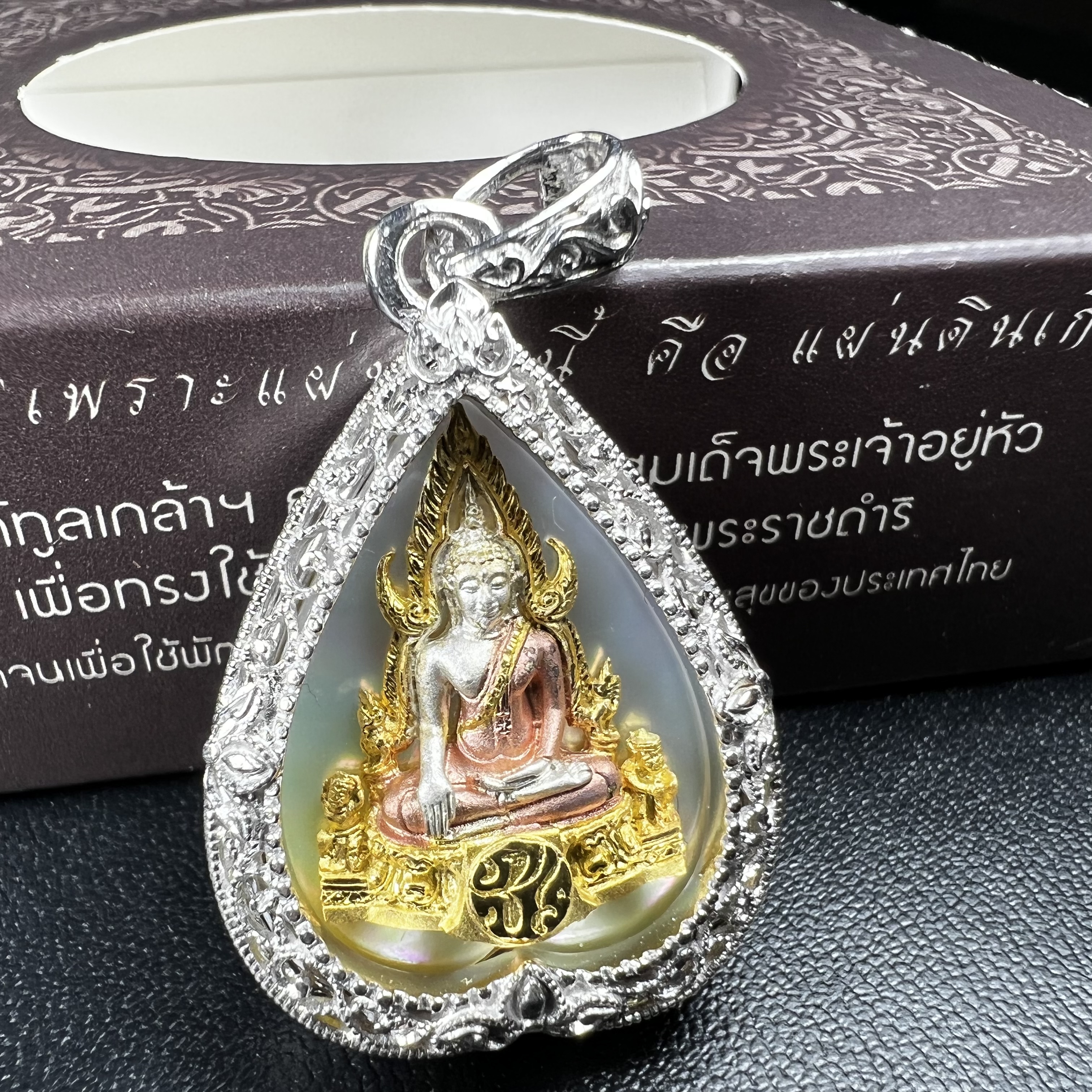 พระพุทธชินราช ภปร. โครงการ "เพราะแผ่นดินนี้ คือ แผ่นดินเกิด" ปี2548(รุ่นแรก) เหรียญทรงใบโพธิ์ ขนาด 21 x 29 มม. เนื้อเงินสามกษัตริย์ องค์พระชุบสามกษัตริย์ ล้อมด้วยกรอบเงินชุบทองคำขาวสลักเสลาเป็นลวดลายละเอียดอ่อน ส่วนพื้นองค์พระเป็นเปลือกหอยมุข