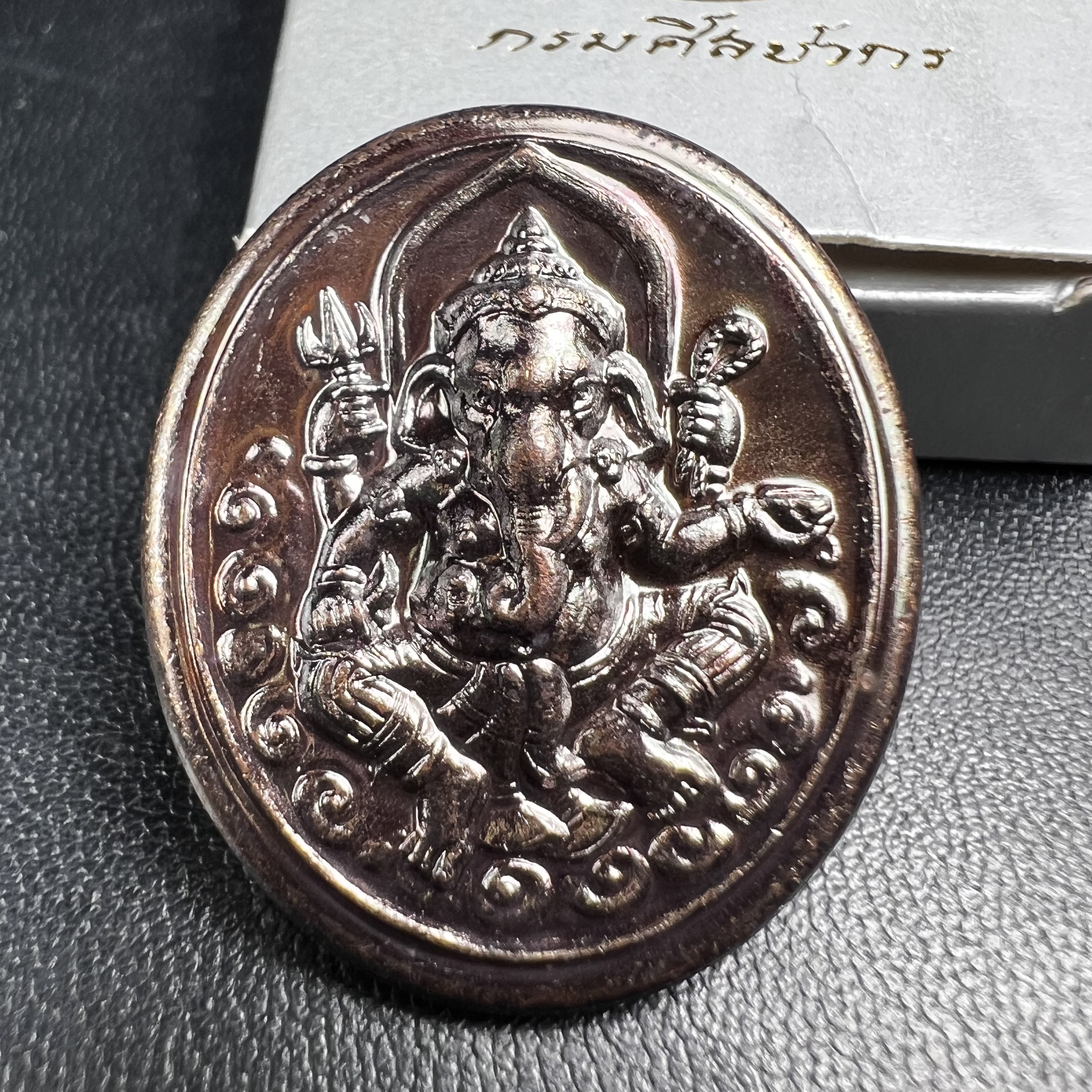 พระพิฆเนศ เทพเจ้าแห่งความสำเร็จและศิลปวิทยาการ กรมศิลปากร ปี 2547 เหรียญทองแดงรมดำ ขนาดสูง 3 ซ.ม. สภาพผิวสวยเดิม พร้อมกล่องบรรจุเดิมครบ