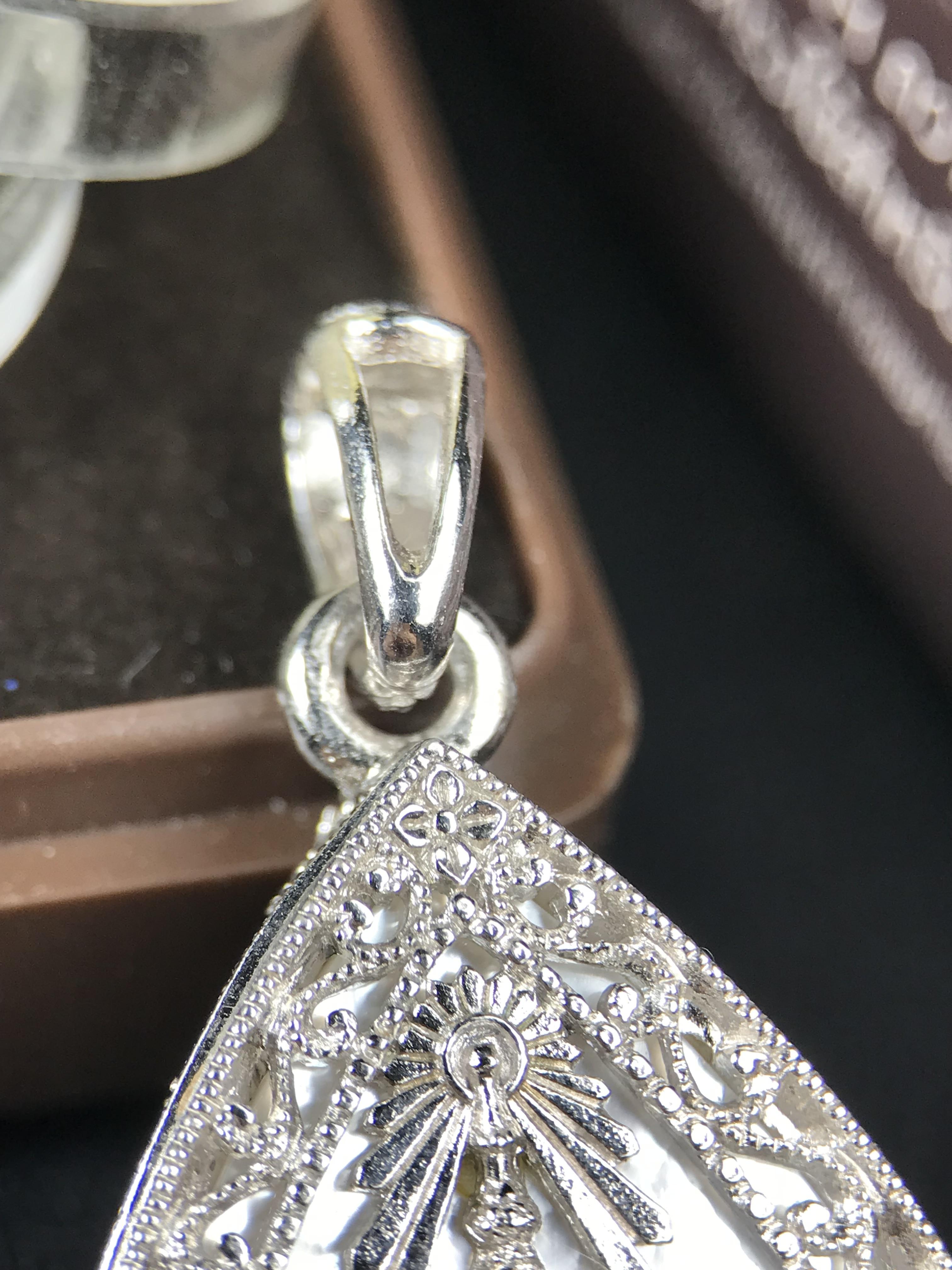 พระพุทธชินราช ภปร. โครงการ "เพราะแผ่นดินนี้ คือ แผ่นดินเกิด" ปี 2548(รุ่นแรก) เหรียญทรงหยดน้ำ ขนาด 21 x 31 มม. เนื้อเงินสามกษัตริย์ องค์พระชุบสามกษัตริย์ ล้อมด้วยกรอบเงินชุบทองคำขาวสลักเสลาเป็นลวดลายละเอียดอ่อน ส่วนพื้นองค์พระเป็นเปลือกหอยมุข