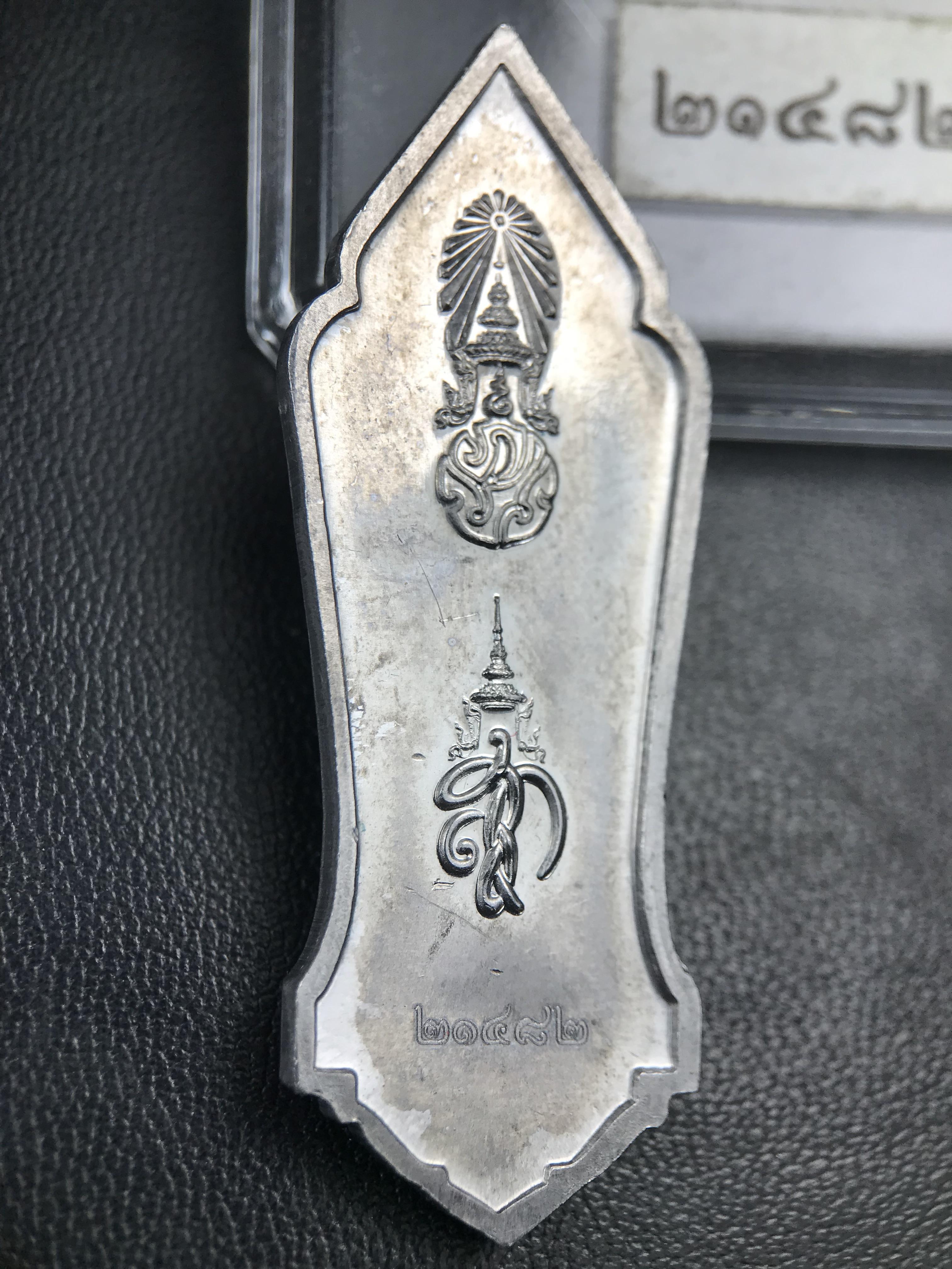 เหรียญที่ระลึกพระพุทธเมตตาประชาไทยไตรโลกนาถคันธารราฐอนุสรณ์ หลัง ภปร. และ สก. วัดทิพย์สุคนธาราม จ.กาญจนบุรี ปี 2558 เนื้อชิน(ตะกั่ว) ขนาดสูง 4.6 ซม. ที่ระลึก ร.9 พระชนมพรรษาครบ 7 รอบ และ สมเด็จพระราชินี พระชนมพรรษา 80 พรรษา พิธีใหญ่