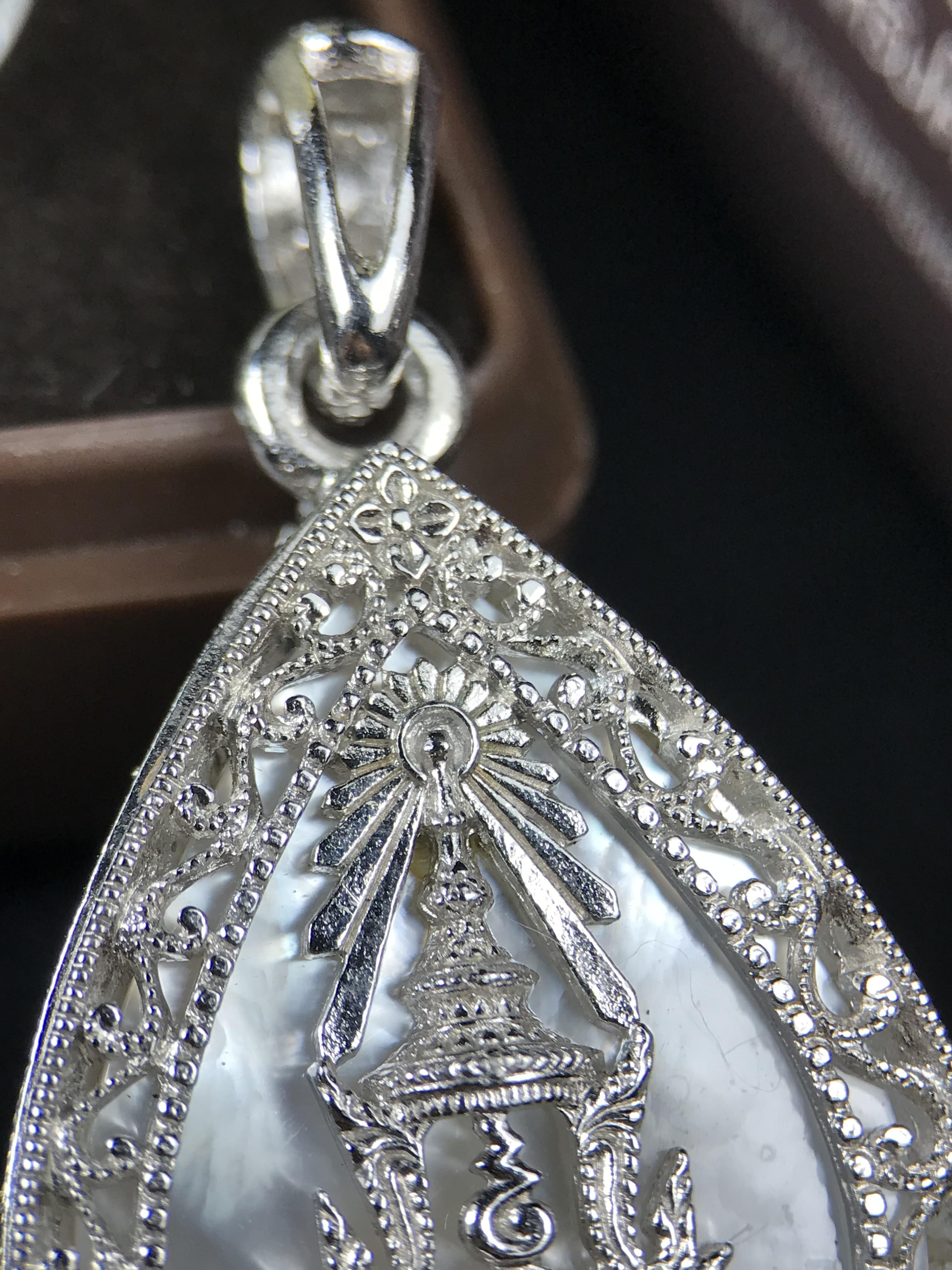 พระพุทธชินราช ภปร. โครงการ "เพราะแผ่นดินนี้ คือ แผ่นดินเกิด" ปี 2548(รุ่นแรก) เหรียญทรงหยดน้ำ ขนาด 21 x 31 มม. เนื้อเงินสามกษัตริย์ องค์พระชุบสามกษัตริย์ ล้อมด้วยกรอบเงินชุบทองคำขาวสลักเสลาเป็นลวดลายละเอียดอ่อน ส่วนพื้นองค์พระเป็นเปลือกหอยมุข