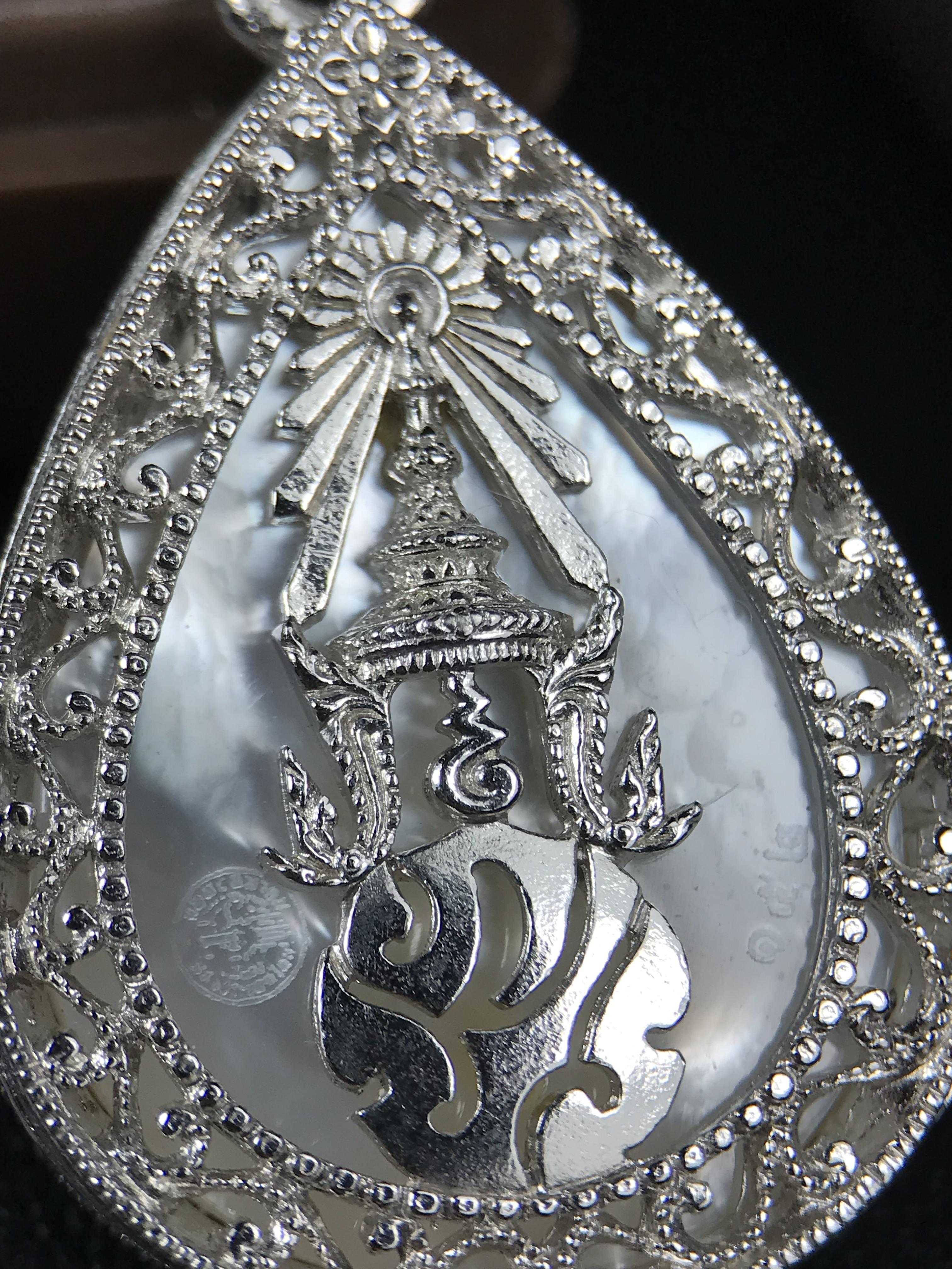 พระพุทธชินราช ภปร. โครงการ "เพราะแผ่นดินนี้ คือ แผ่นดินเกิด" ปี 2548(รุ่นแรก) เหรียญทรงหยดน้ำ ขนาด 21 x 31 มม. เนื้อเงินสามกษัตริย์ องค์พระชุบสามกษัตริย์ ล้อมด้วยกรอบเงินชุบทองคำขาวสลักเสลาเป็นลวดลายละเอียดอ่อน ส่วนพื้นองค์พระเป็นเปลือกหอยมุข