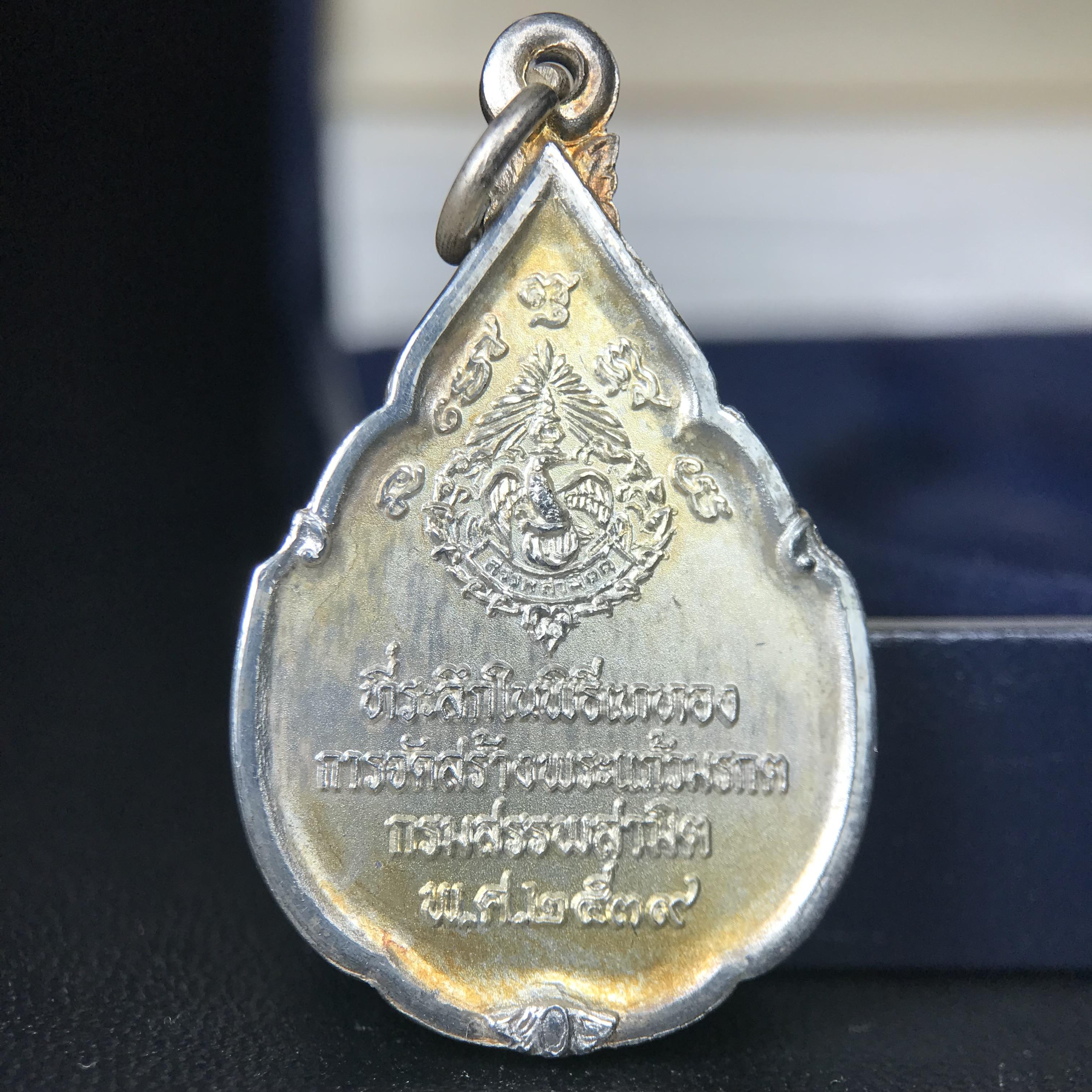 เหรียญพระแก้วมรกต ที่ระลึกในพิธีเททองการจัดสร้างพระแก้วมรกตกรมสรรพสามิต พ.ศ.2539 และในวโรกาสที่พระบาทสมเด็จพระเจ้าอยู่หัวทรงครองราชย์ครบ 50 ปี เนื้อเงิน ทรงหยดน้ำ(พิมพ์มีหูห่วง)(สภาพผิวเดิมขึ้นรุ้งสวยมาก)(พิธีใหญ่)**เนื้อเงินรุ่นนี้พบเจอน้อยมาก**