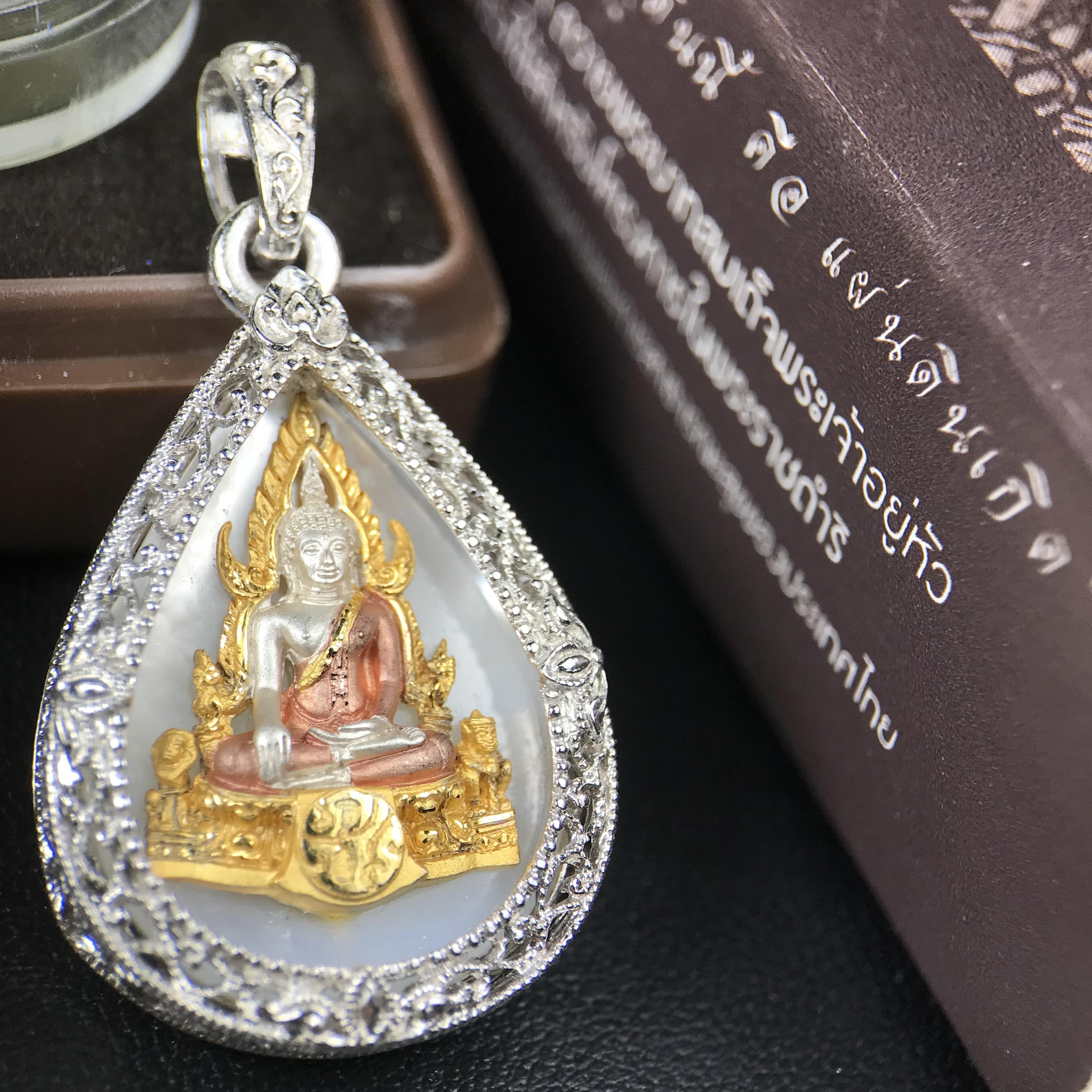 พระพุทธชินราช ภปร. โครงการ "เพราะแผ่นดินนี้ คือ แผ่นดินเกิด" ปี 2548(รุ่นแรก) เหรียญทรงหยดน้ำ ขนาด 21 x 31 มม. เนื้อเงินสามกษัตริย์ องค์พระชุบสามกษัตริย์ ล้อมด้วยกรอบเงินชุบทองคำขาวสลักเสลาเป็นลวดลายละเอียดอ่อน ส่วนพื้นองค์พระเป็นเปลือกหอยมุข
