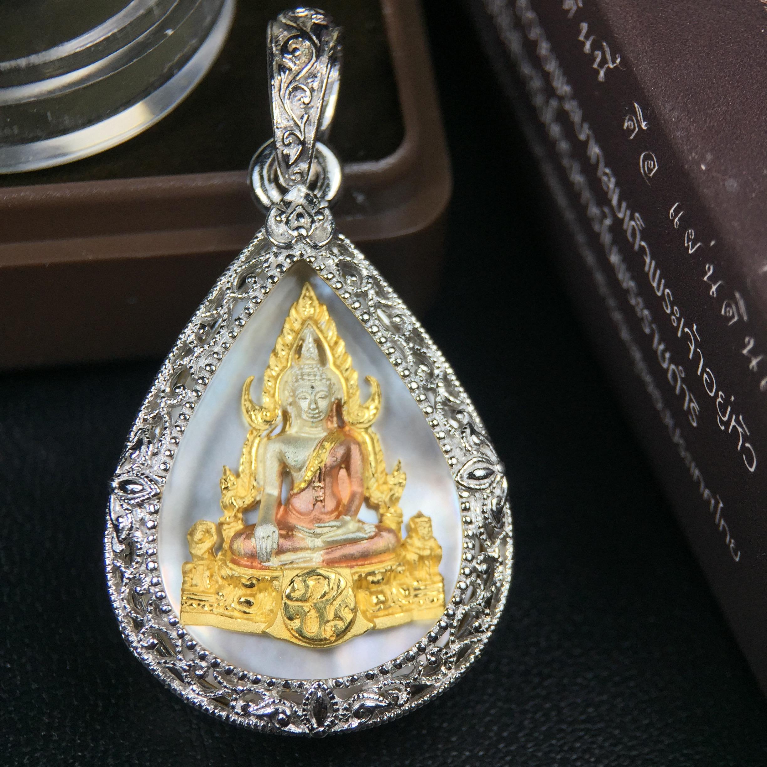 พระพุทธชินราช ภปร. โครงการ "เพราะแผ่นดินนี้ คือ แผ่นดินเกิด" ปี2548(รุ่นแรก) เหรียญทรงหยดน้ำ ขนาด 21 x 31 มม. เนื้อเงินสามกษัตริย์ องค์พระชุบสามกษัตริย์ ล้อมด้วยกรอบเงินชุบทองคำขาวสลักเสลาเป็นลวดลายละเอียดอ่อน ส่วนพื้นองค์พระเป็นเปลือกหอยมุข