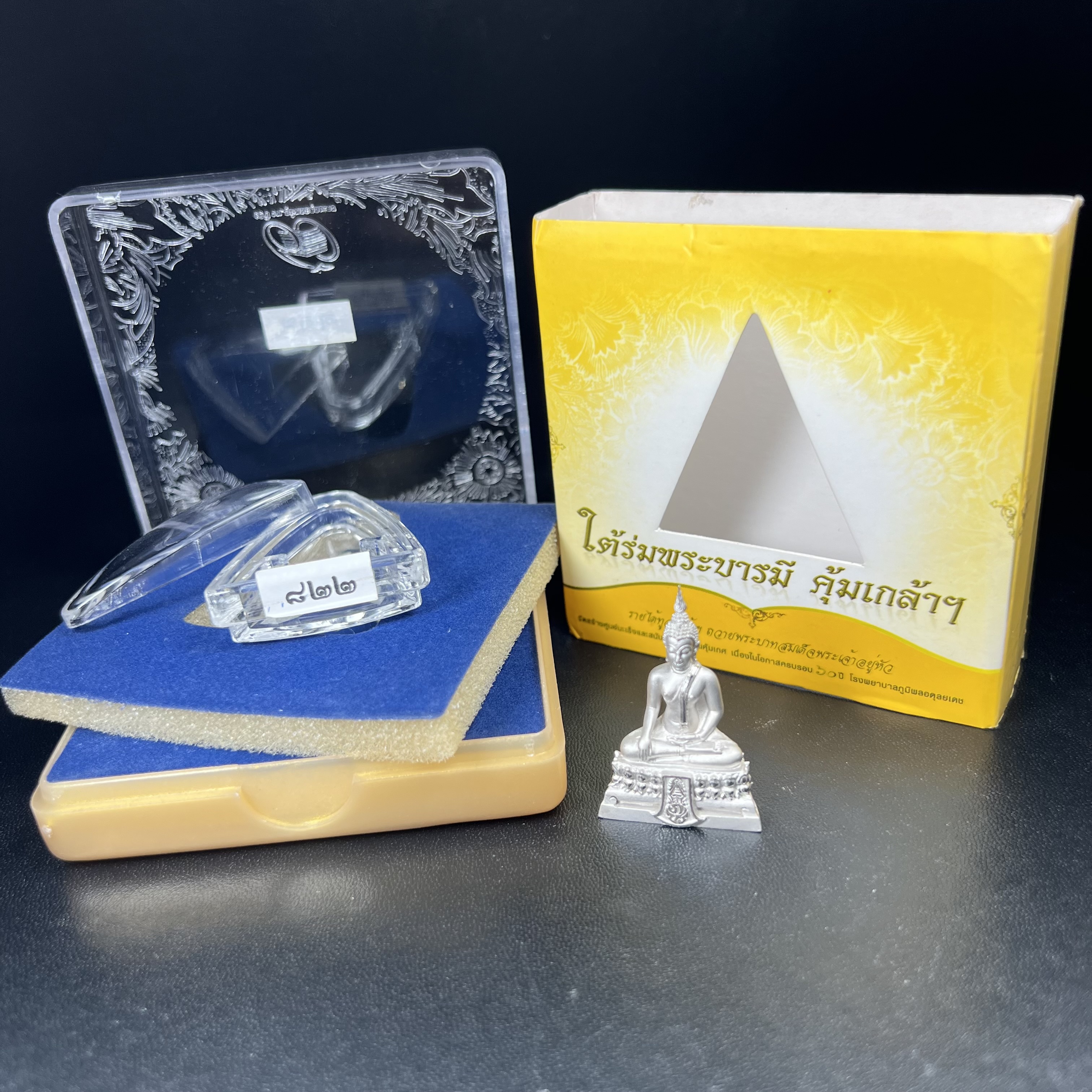 พระพุทธรูปคุ้มเกล้า ภปร.(ใต้ร่มพระบารมี คุ้มเกล้า) 60ปี โรงพยาบาลภูมิพลฯ พ.ศ.2552 เนื้อเงิน ชุบทองคำขาว(พิมพ์ใหญ่ขนาด 35.5*24 มม.)สภาพสวยเดิมพร้อมกล่องบรรจุเดิม ตอกโค๊ดหมายเลข ๘๒๒ หายาก(1ใน5000 องค์)