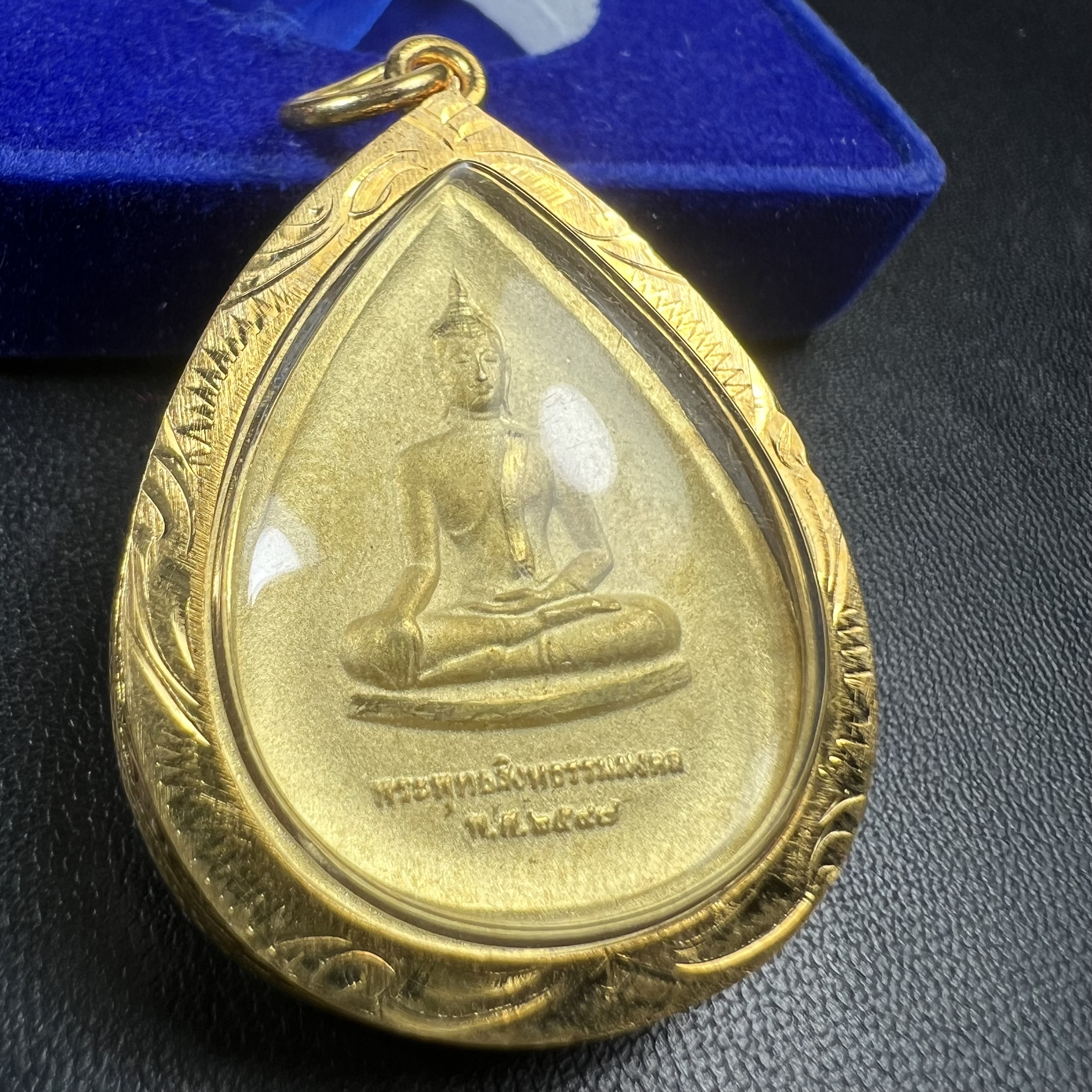 เหรียญพระพุทธสิงหธรรมมงคล ภปร. ปี 2547 ทรงหยดน้ำ ด้านหลังมี ภ.ป.ร. (ชนวนเก่า)เนื้อโลหะผสม ชุบทองพ่นทราย สูง 3.3ซม.พิธีใหญ่ มวลสารดี ปลุกเสกวัดพระแก้ว(งานเลี่ยมกรอบเดิมจากผู้จัดสร้างห่อหุ้มด้วยทองนพเกล้า)