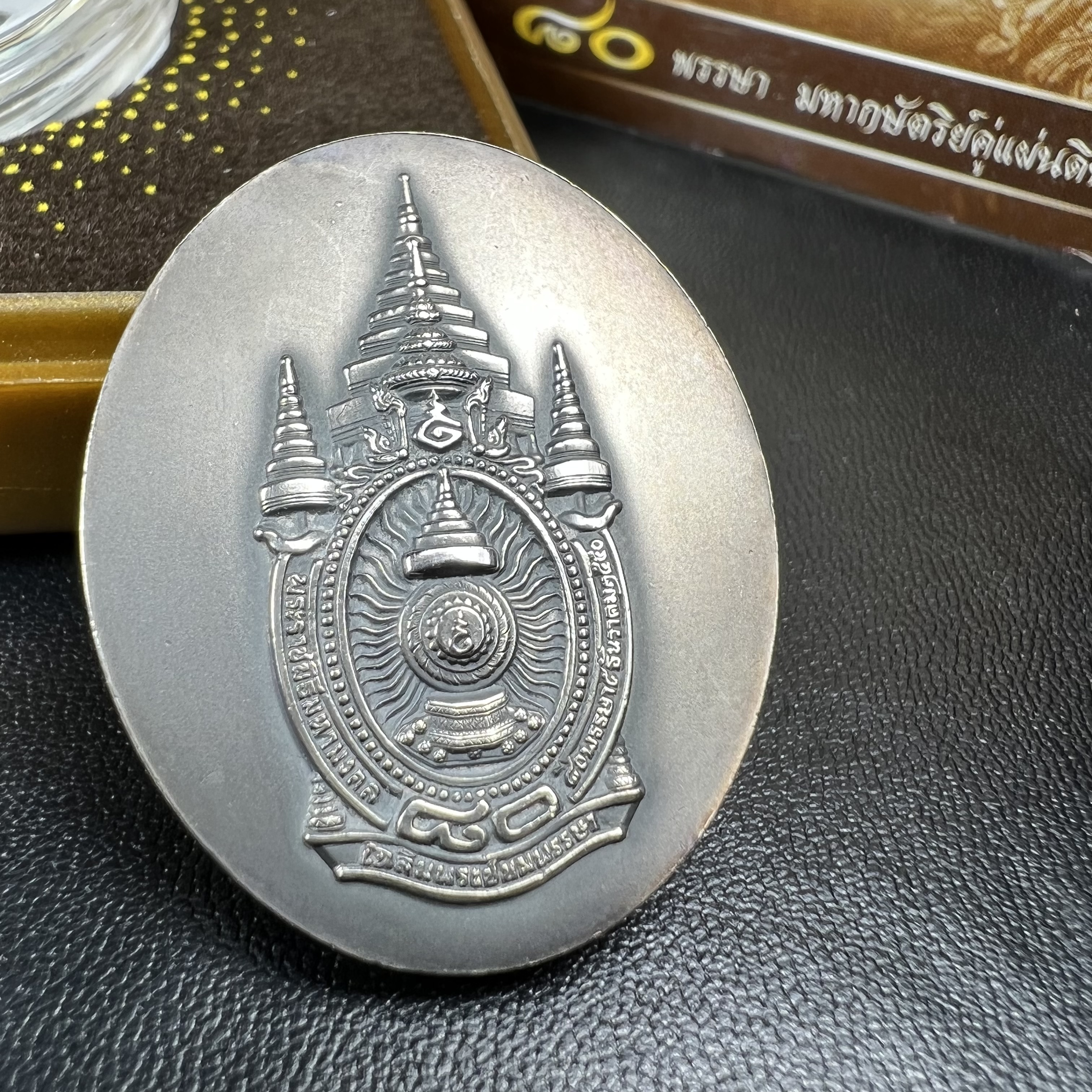 เหรียญรูปหล่อพระบาทสมเด็จพระเจ้าอยู่หัว ในหลวงทรงงาน “รุ่นเย็นศิระเพราะพระบริบาล 80พรรษา มหากษัตริย์คู่แผ่นดินสยาม” พ.ศ.2550 เนื้อเงินรมดำ(ขนาด 27*35 มม.) พร้อมกล่องบรรจุเดิมครบ