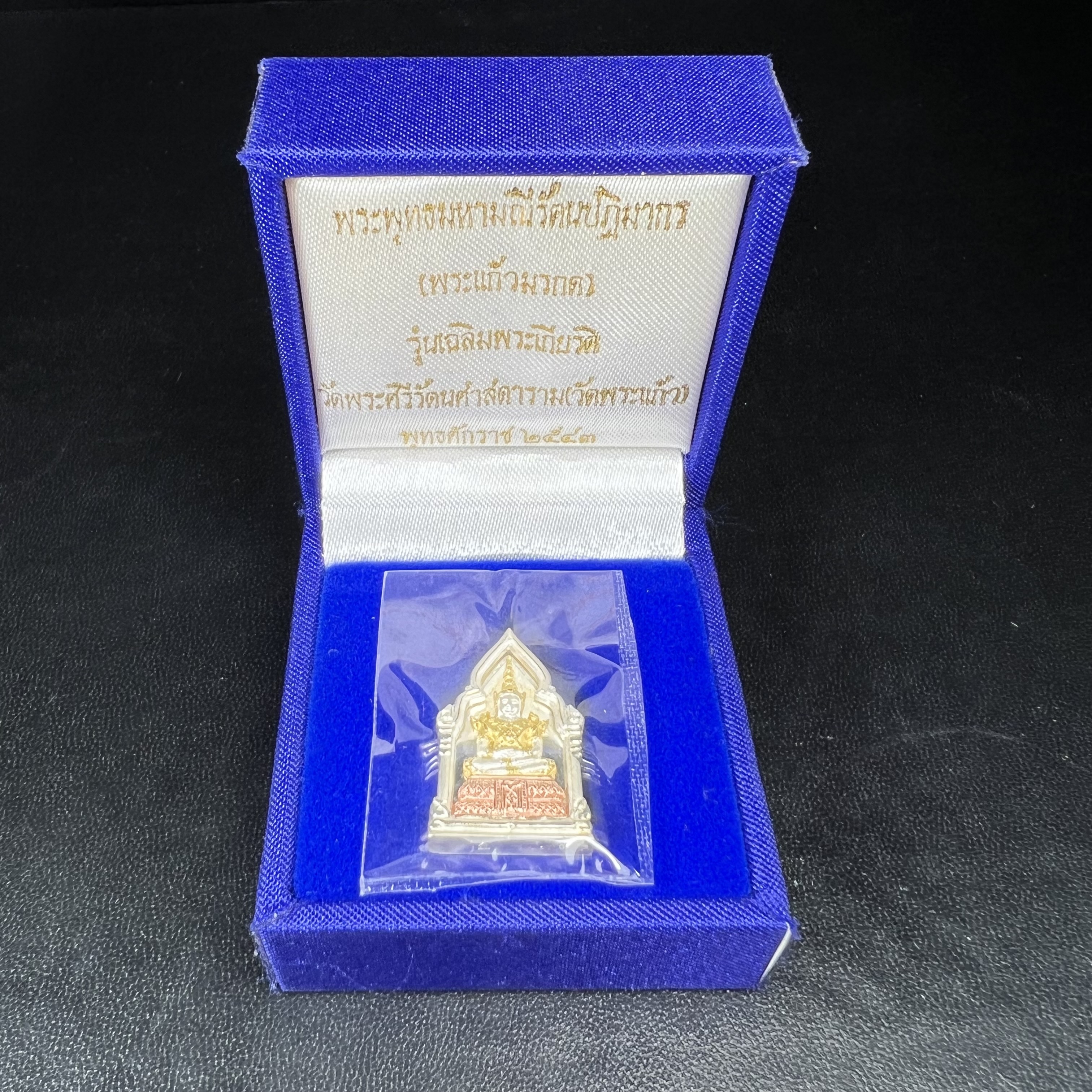 พระพุทธมหามณีรัตนปฎิมากร(พระแก้วมรกต)รุ่น เฉลิมพระเกียรติ วัดพระศรีรัตนศาสดารามราม(วัดพระแก้ว) ปี2543 เนื้อเงินสามกษัตริย์พิมพ์ซุ้มกนกเล็ก ขนาด สูง 2.5 ซ.ม. สภาพสวยซีนเดิมกล่องครบ(องค์หมายเลข ๘๗๙)