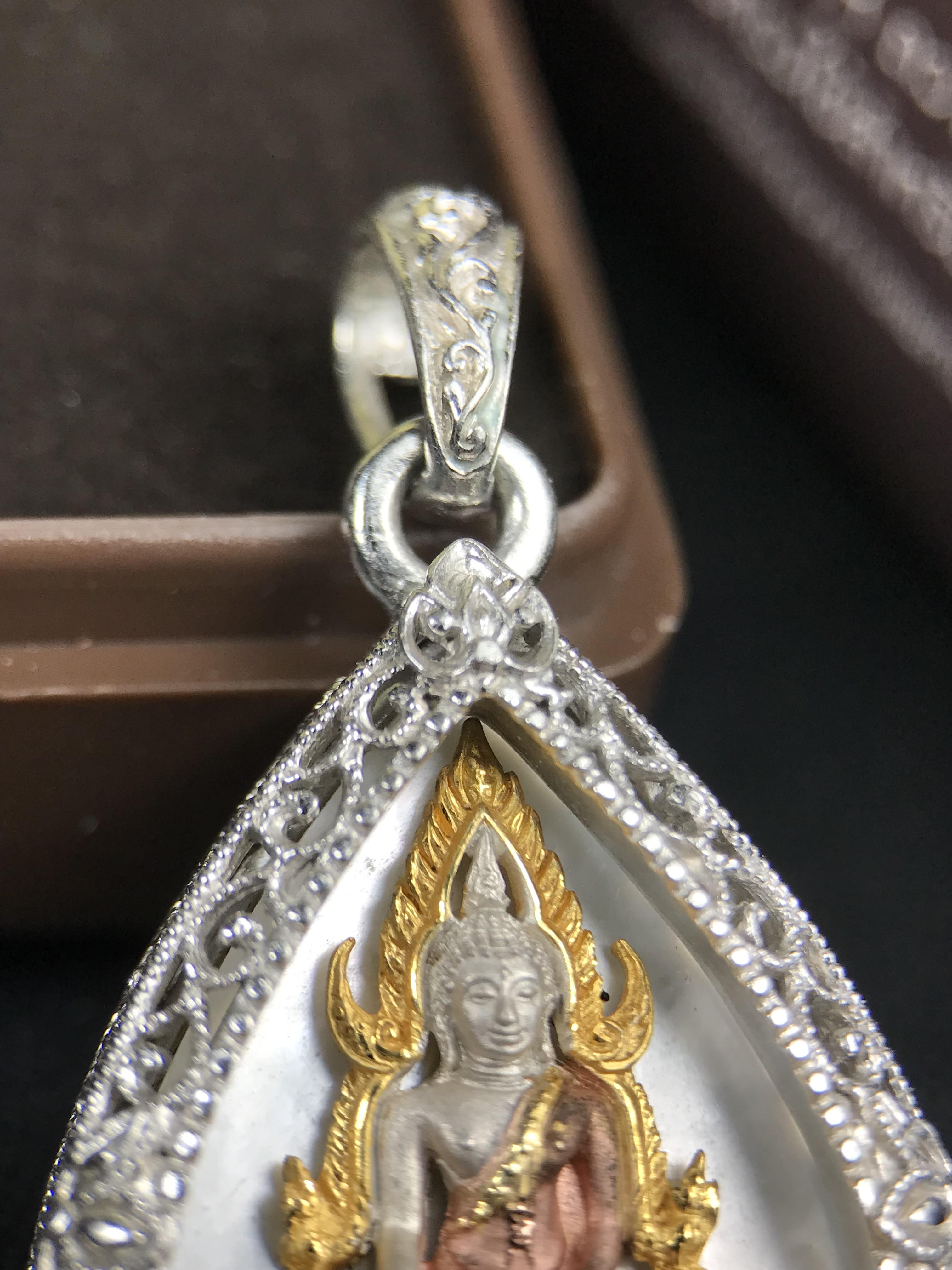 พระพุทธชินราช ภปร. โครงการ "เพราะแผ่นดินนี้ คือ แผ่นดินเกิด" ปี 2548(รุ่นแรก) เหรียญทรงใบโพธิ์ ขนาด 21 x 29 มม. เนื้อเงินสามกษัตริย์ องค์พระชุบสามกษัตริย์ ล้อมด้วยกรอบเงินชุบทองคำขาวสลักเสลาเป็นลวดลายละเอียดอ่อน ส่วนพื้นองค์พระเป็นเปลือกหอยมุข