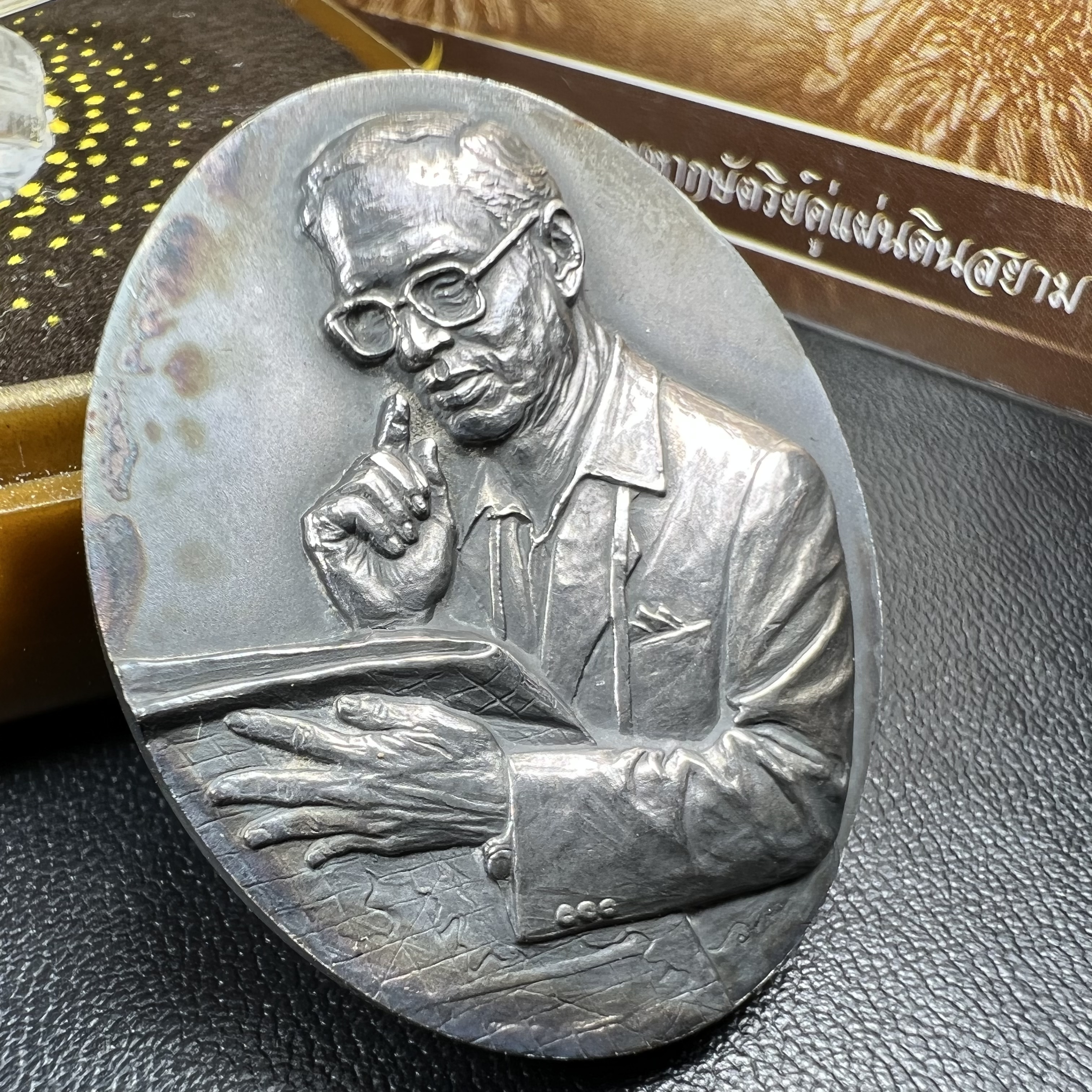 เหรียญรูปหล่อพระบาทสมเด็จพระเจ้าอยู่หัว ในหลวงทรงงาน “รุ่นเย็นศิระเพราะพระบริบาล 80พรรษา มหากษัตริย์คู่แผ่นดินสยาม” พ.ศ.2550 เนื้อเงินรมดำ(ขนาด 27*35 มม.) พร้อมกล่องบรรจุเดิมครบ