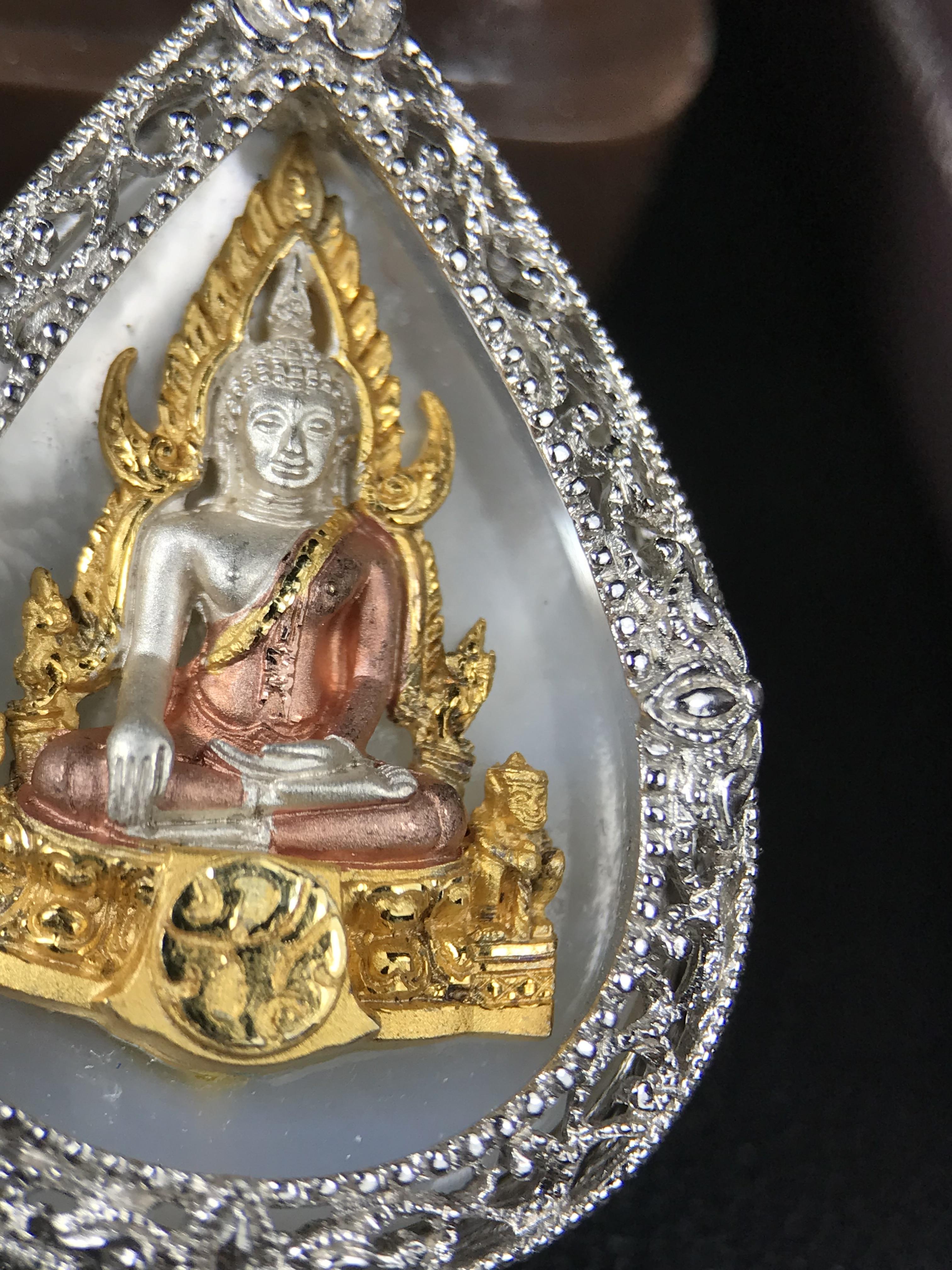 พระพุทธชินราช ภปร. โครงการ "เพราะแผ่นดินนี้ คือ แผ่นดินเกิด" ปี 2548(รุ่นแรก) เหรียญทรงหยดน้ำ ขนาด 21 x 31 มม. เนื้อเงินสามกษัตริย์ องค์พระชุบสามกษัตริย์ ล้อมด้วยกรอบเงินชุบทองคำขาวสลักเสลาเป็นลวดลายละเอียดอ่อน ส่วนพื้นองค์พระเป็นเปลือกหอยมุข