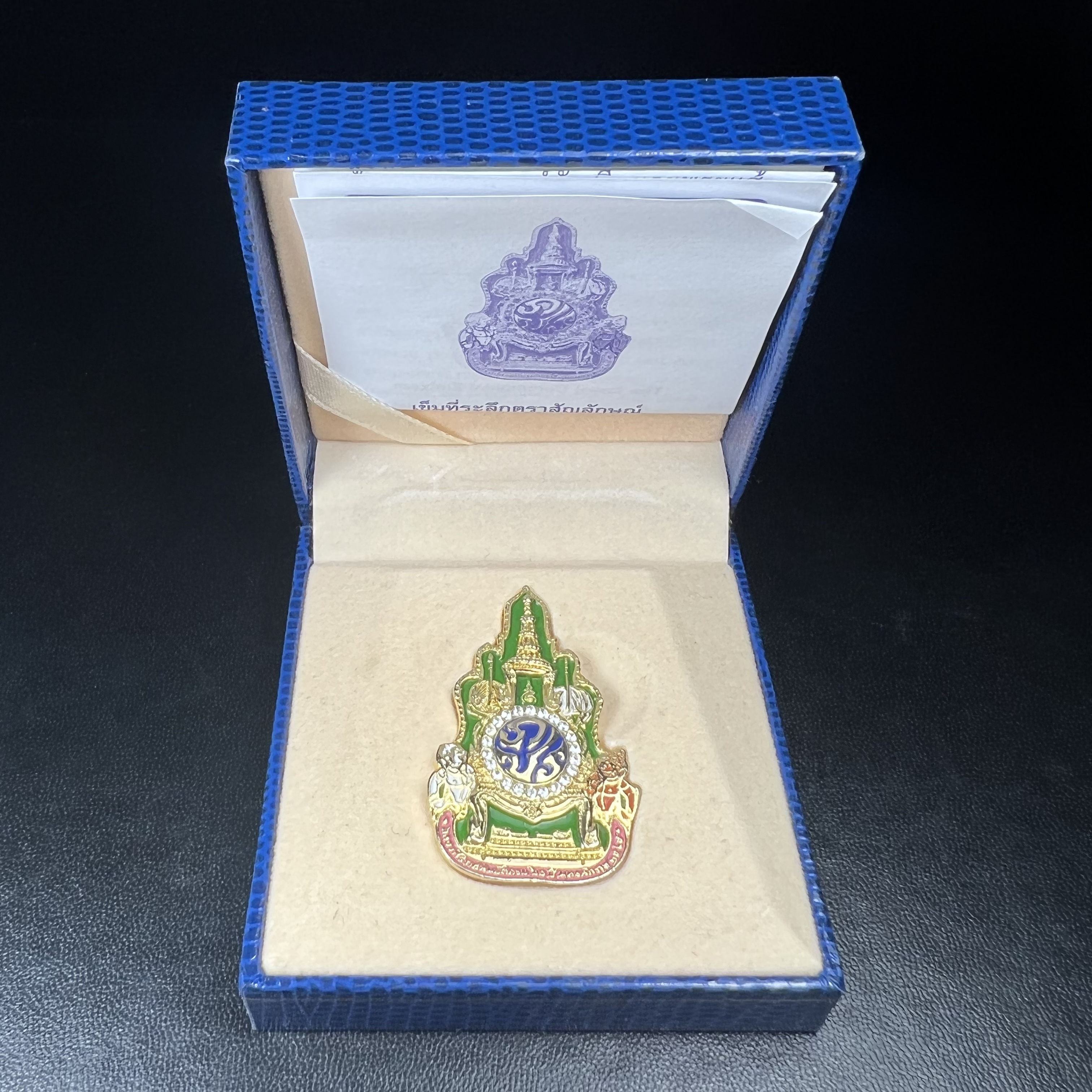 เข็มที่ระลึกตราสัญลักษณ์งานฉลองสิริราชสมบัติครบ 60 ปี พุทธศักราช 2549 ในหลวงรัชการที่ 9 จัดทำขึ้นโดยสำนักงานปลัดสำนักนายกรัฐมนตรี