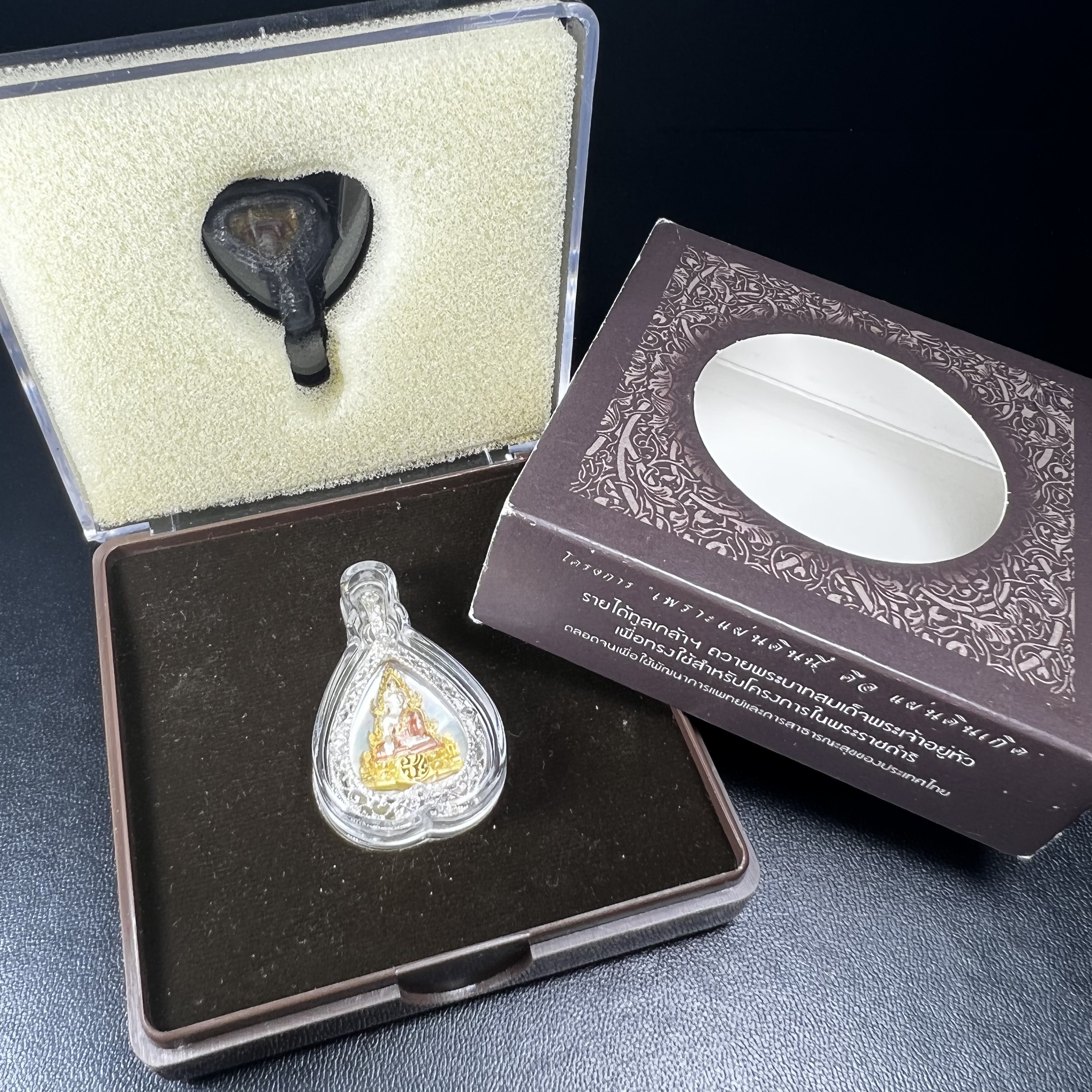 พระพุทธชินราช ภปร. โครงการ "เพราะแผ่นดินนี้ คือ แผ่นดินเกิด" ปี2548(รุ่นแรก) เหรียญทรงใบโพธิ์ ขนาด 21 x 29 มม. เนื้อเงินสามกษัตริย์ องค์พระชุบสามกษัตริย์ ล้อมด้วยกรอบเงินชุบทองคำขาวสลักเสลาเป็นลวดลายละเอียดอ่อน ส่วนพื้นองค์พระเป็นเปลือกหอยมุข