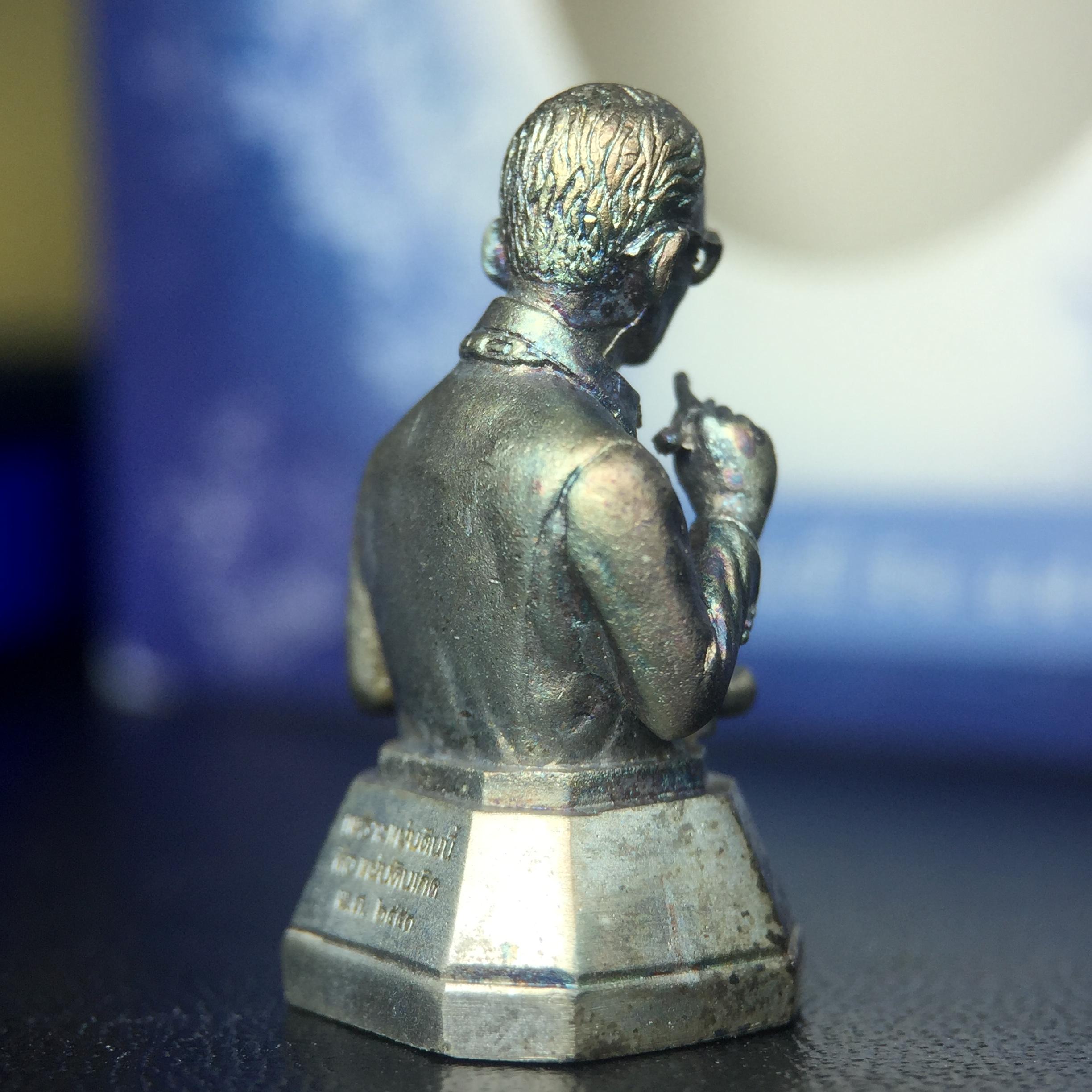 พระบรมรูปพระบาทสมเด็จพระเจ้าอยู่หัวรัชกาลที่ 9(ทรงงาน) ภปร. รุ่นเพราะแผ่นดินนี้คือแผ่นดินเกิด ปี 2551 ขนาดสูง 1 นิ้ว เนื้อเงิน(ผิวเดิมขึ้นสีรุ้งธรรมชาติสวยมาก)(ด้านหน้า ฐานพระบรมรูปฯ ประดิษฐานอักษรพระปรมาภิไธย ภ.ป.ร.)นิยมหายาก(1 ใน 5000 องค์)