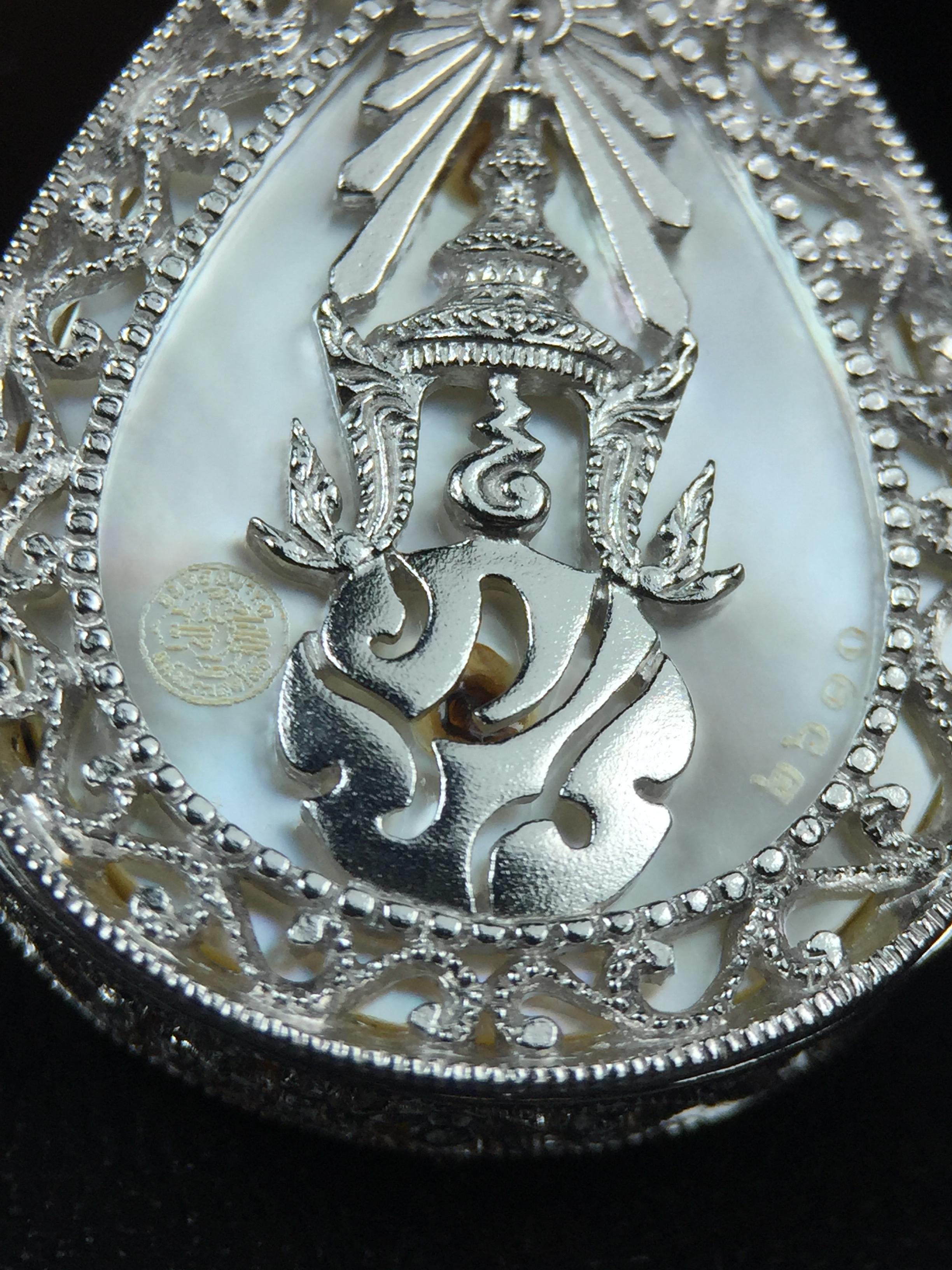 พระพุทธชินราช ภปร. โครงการ "เพราะแผ่นดินนี้ คือ แผ่นดินเกิด" ปี2548(รุ่นแรก) เหรียญทรงหยดน้ำ ขนาด 21 x 31 มม. เนื้อเงินสามกษัตริย์ องค์พระชุบสามกษัตริย์ ล้อมด้วยกรอบเงินชุบทองคำขาวสลักเสลาเป็นลวดลายละเอียดอ่อน ส่วนพื้นองค์พระเป็นเปลือกหอยมุข