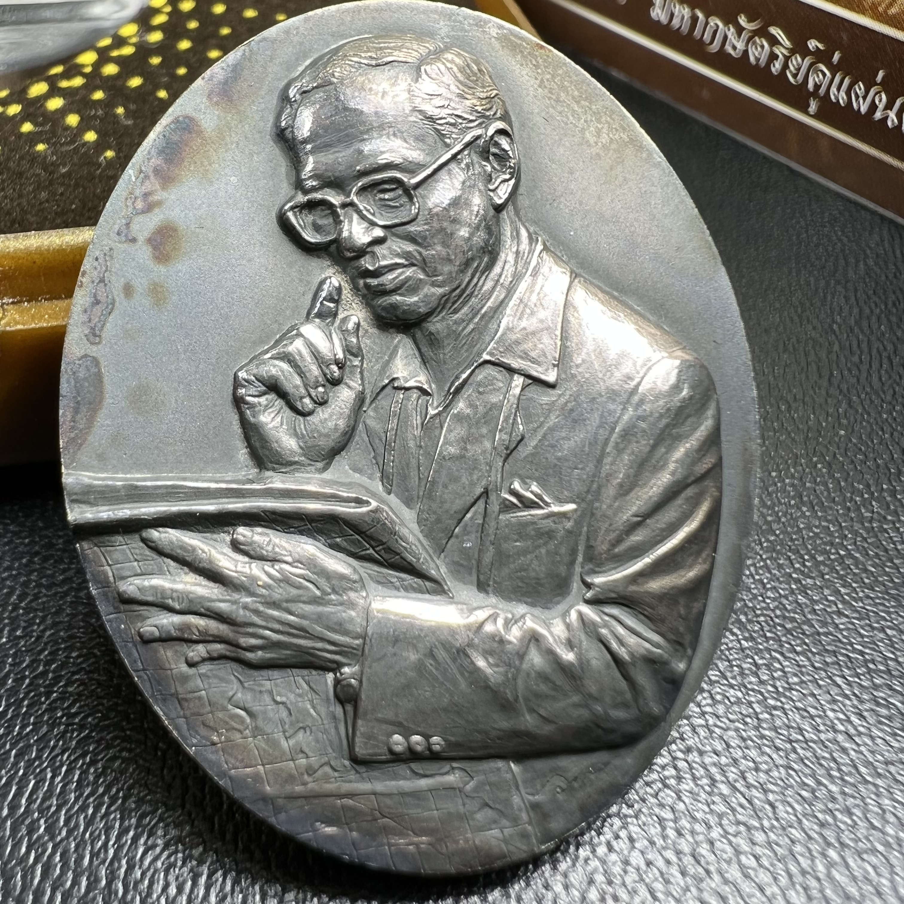 เหรียญรูปหล่อพระบาทสมเด็จพระเจ้าอยู่หัว ในหลวงทรงงาน “รุ่นเย็นศิระเพราะพระบริบาล 80พรรษา มหากษัตริย์คู่แผ่นดินสยาม” พ.ศ.2550 เนื้อเงินรมดำ(ขนาด 27*35 มม.) พร้อมกล่องบรรจุเดิมครบ