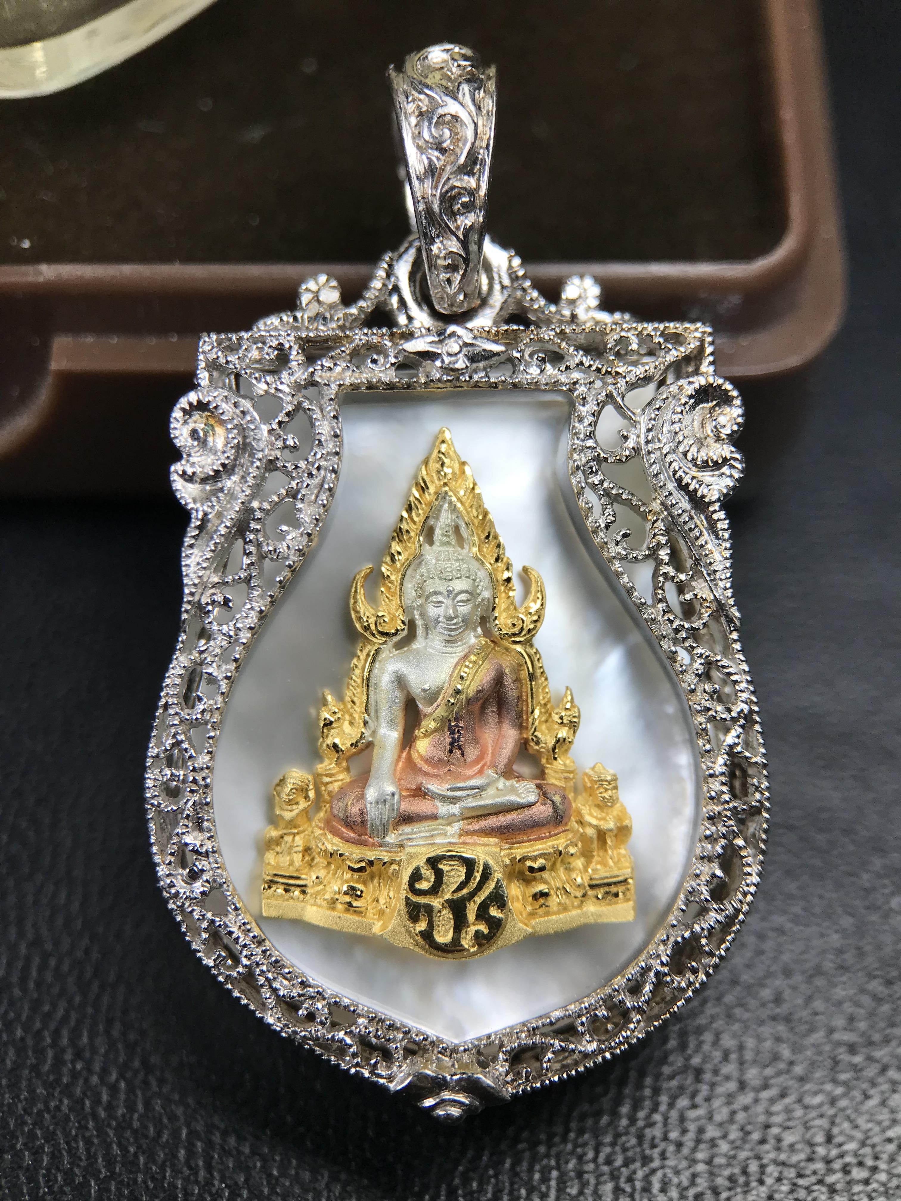 พระพุทธชินราช ภปร. โครงการ "เพราะแผ่นดินนี้ คือ แผ่นดินเกิด" ปี2548(รุ่นแรก) เหรียญทรงเสมา ขนาด 21 x 29 มม.เนื้อเงินสามกษัตริย์ องค์พระชุบสามกษัตริย์ ล้อมด้วยกรอบเงินชุบทองคำขาวสลักเสลาเป็นลวดลายละเอียดอ่อน ส่วนพื้นองค์พระเป็นเปลือกหอยมุขงดงาม