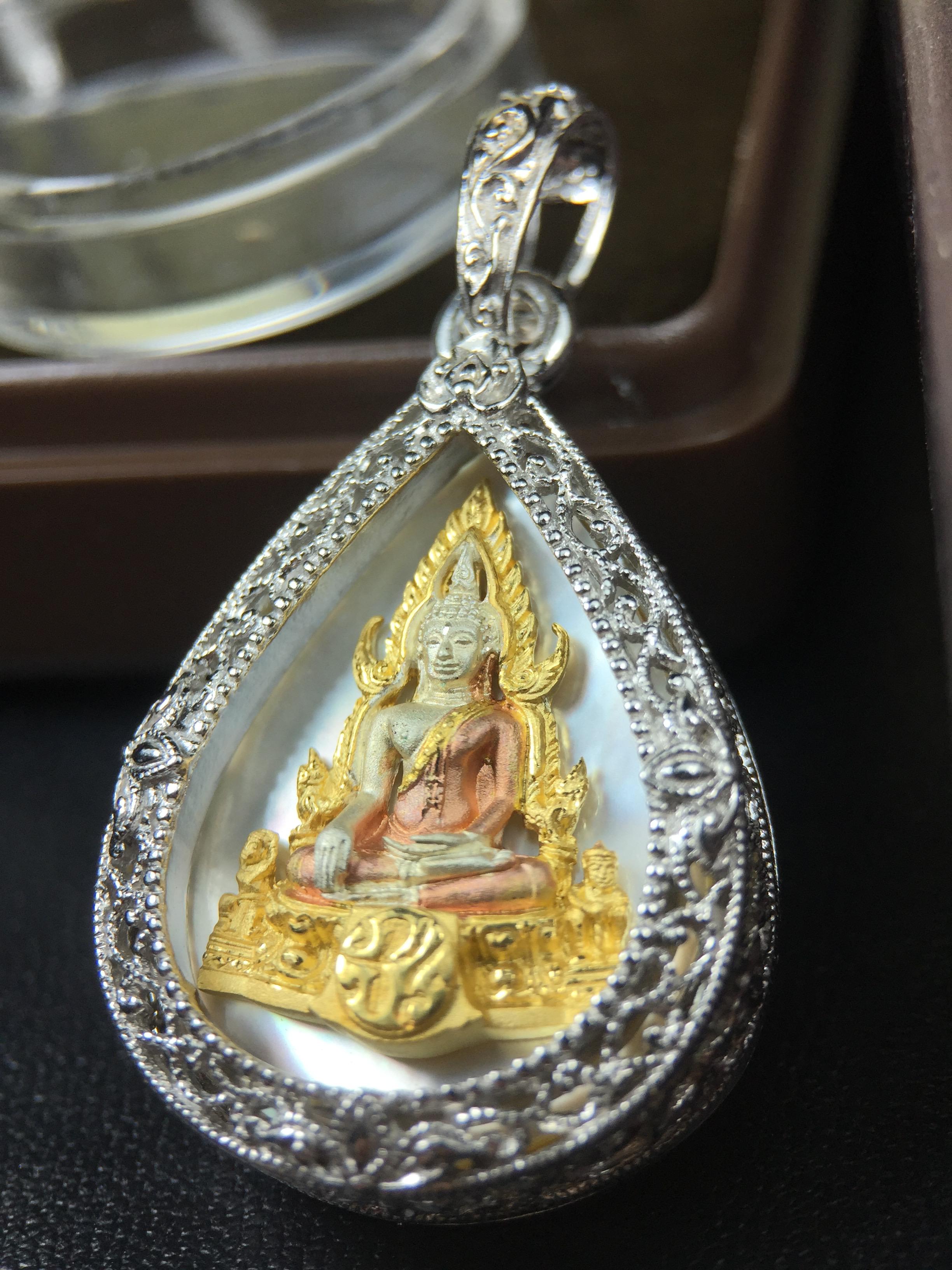 พระพุทธชินราช ภปร. โครงการ "เพราะแผ่นดินนี้ คือ แผ่นดินเกิด" ปี2548(รุ่นแรก) เหรียญทรงหยดน้ำ ขนาด 21 x 31 มม. เนื้อเงินสามกษัตริย์ องค์พระชุบสามกษัตริย์ ล้อมด้วยกรอบเงินชุบทองคำขาวสลักเสลาเป็นลวดลายละเอียดอ่อน ส่วนพื้นองค์พระเป็นเปลือกหอยมุข