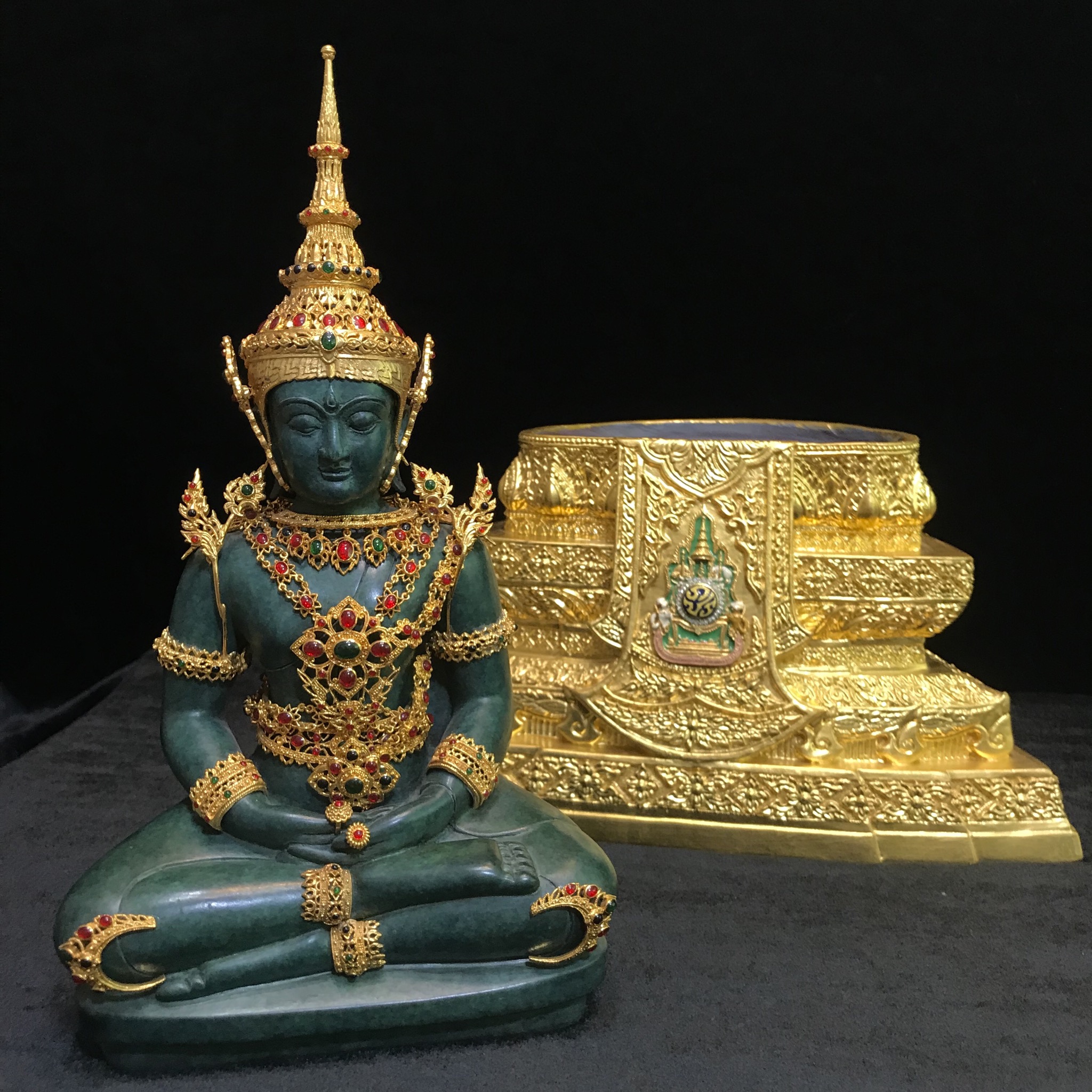 พระแก้วมรกต(จำลอง)ลอยองค์ ขนาดหน้าตัก 5 นิ้ว ทรงเครื่องฤดูร้อน เนื้อโลหะเคลือบสีเขียว เครื่องทรงชุบทองลงยาสี ฐานเนื้อโลหะ ลงรักปิดทองคำ ประดิษฐานตราสัญลักษณ์ฉลองสิริราชสมบัติ ครบ 60 ปี