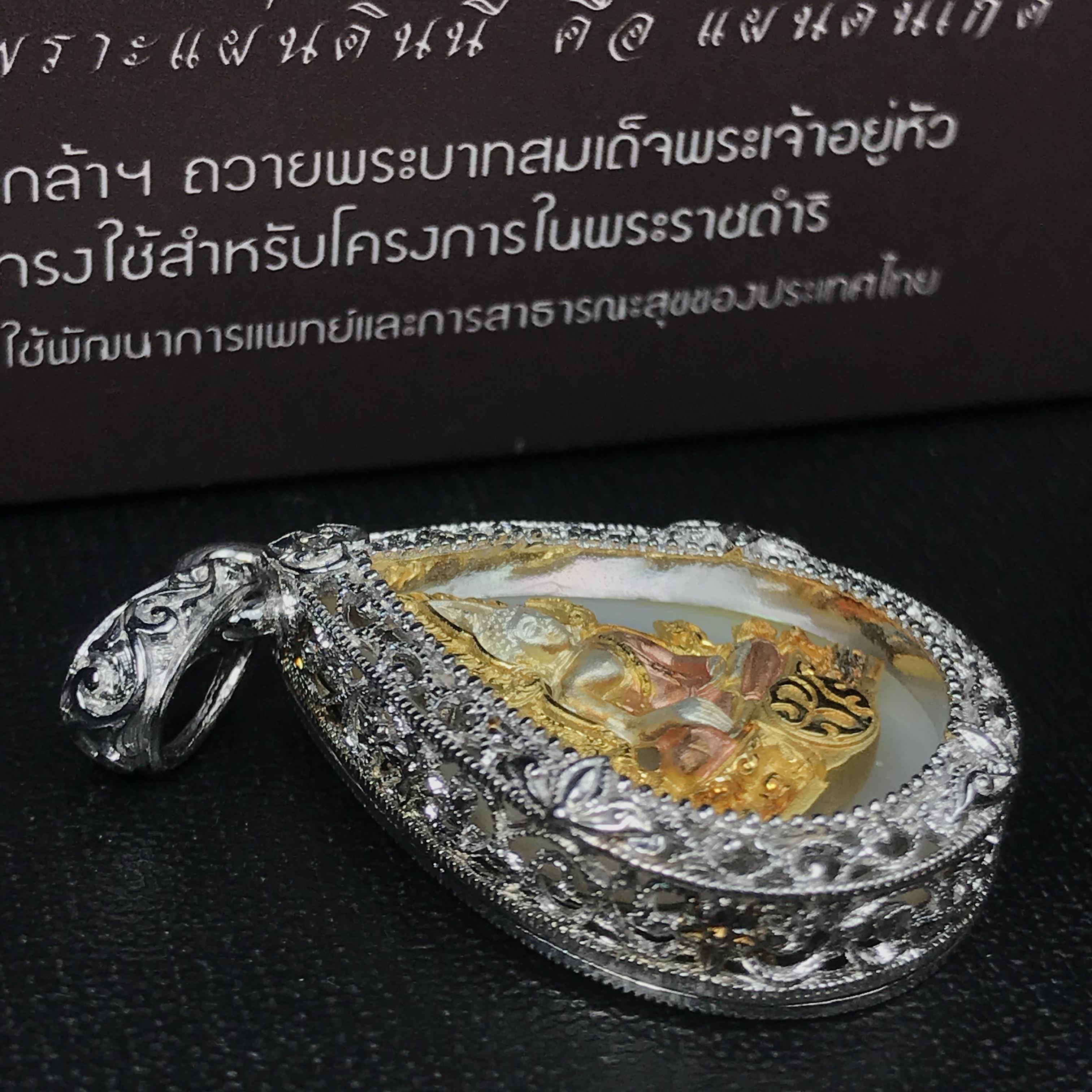 พระพุทธชินราช ภปร. โครงการ "เพราะแผ่นดินนี้ คือ แผ่นดินเกิด" ปี2548(รุ่นแรก) เหรียญทรงหยดน้ำ ขนาด 21 x 31 มม. เนื้อเงินสามกษัตริย์ องค์พระชุบสามกษัตริย์ ล้อมด้วยกรอบเงินชุบทองคำขาวสลักเสลาเป็นลวดลายละเอียดอ่อน ส่วนพื้นองค์พระเป็นเปลือกหอยมุข