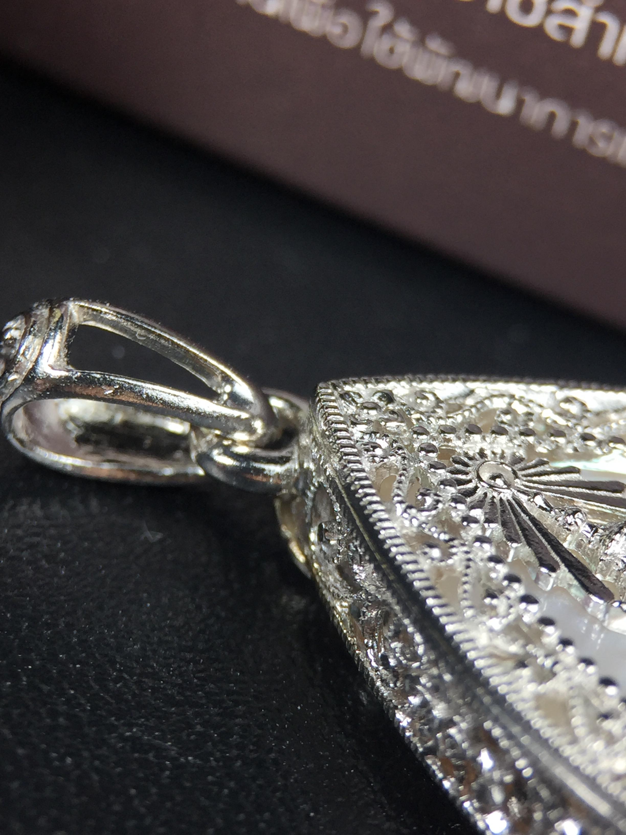 พระพุทธชินราช ภปร. โครงการ "เพราะแผ่นดินนี้ คือ แผ่นดินเกิด" ปี2548(รุ่นแรก) เหรียญทรงใบโพธิ์ ขนาด 21 x 29 มม. เนื้อเงินสามกษัตริย์ องค์พระชุบสามกษัตริย์ ล้อมด้วยกรอบเงินชุบทองคำขาวสลักเสลาเป็นลวดลายละเอียดอ่อน ส่วนพื้นองค์พระเป็นเปลือกหอยมุข