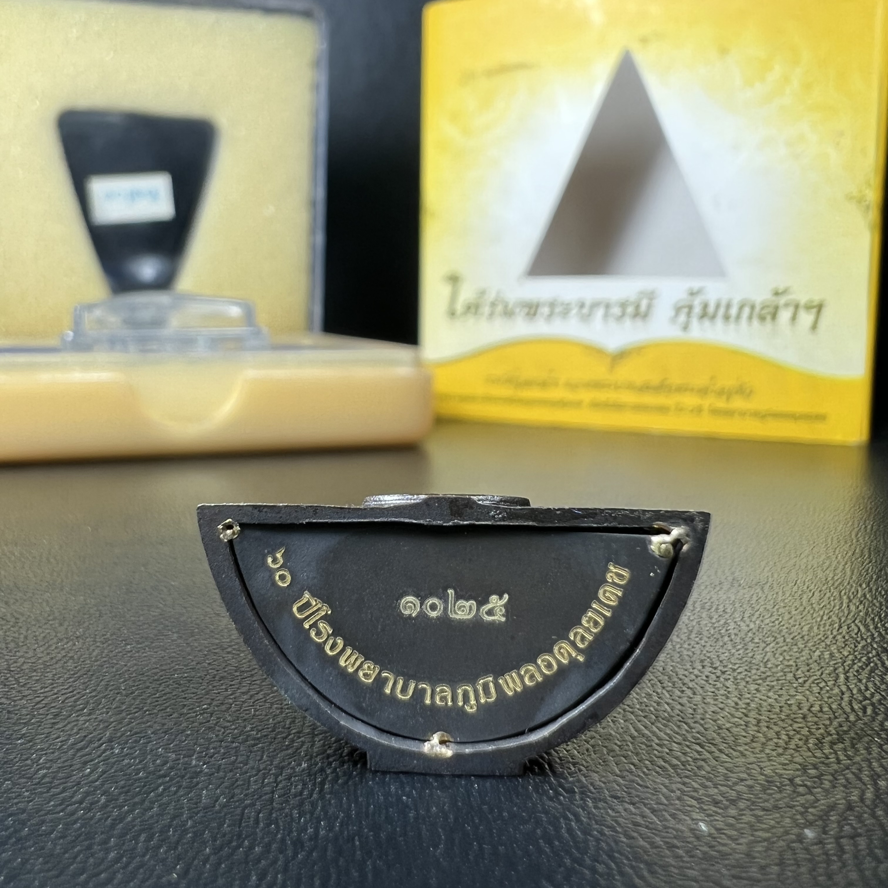 พระพุทธรูปคุ้มเกล้าฯ ภปร.(ใต้ร่มพระบารมี คุ้มเกล้า) 60ปี รพ.ภูมิพลฯ พ.ศ.2552 เนื้อนวโลหะ รมดำ(พิมพ์ใหญ่ขนาด 35.5*24 มม.)