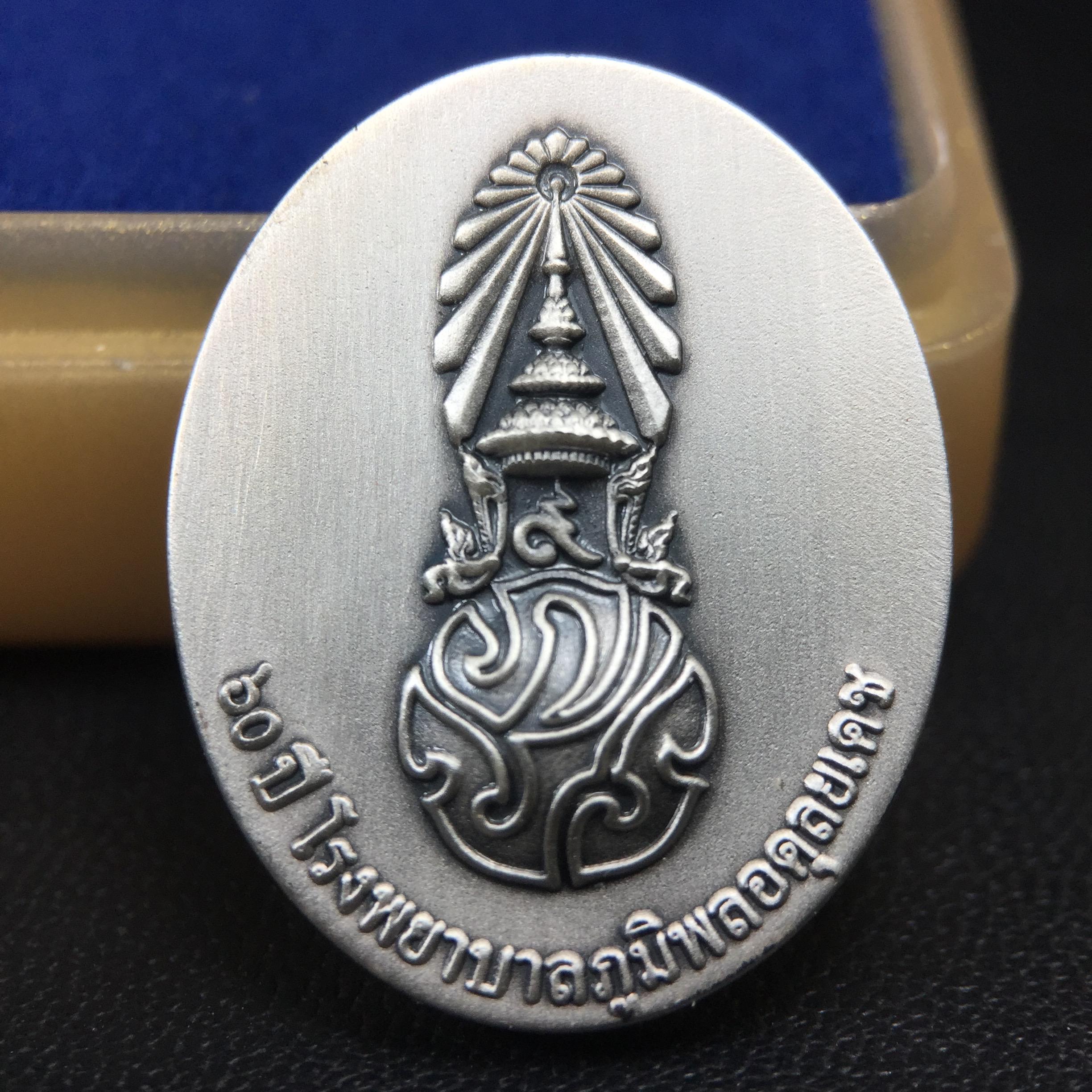 เหรียญพระบาทสมเด็จพระเจ้าอยู่หัวรัชกาลที่ 9 ภปร.(ใต้ร่มพระบารมี คุ้มเกล้า) 60ปี โรงพยาบาลภูมิพลฯ พ.ศ.2552 เนื้อเงิน (พิมพ์เล็กขนาด 25*20 มม.)สภาพสวยเดิมพร้อมกล่องบรรจุเดิม ตอกโค๊ดหมายเลขกำกับ เนื้อเงินหายากพบเจอน้อย