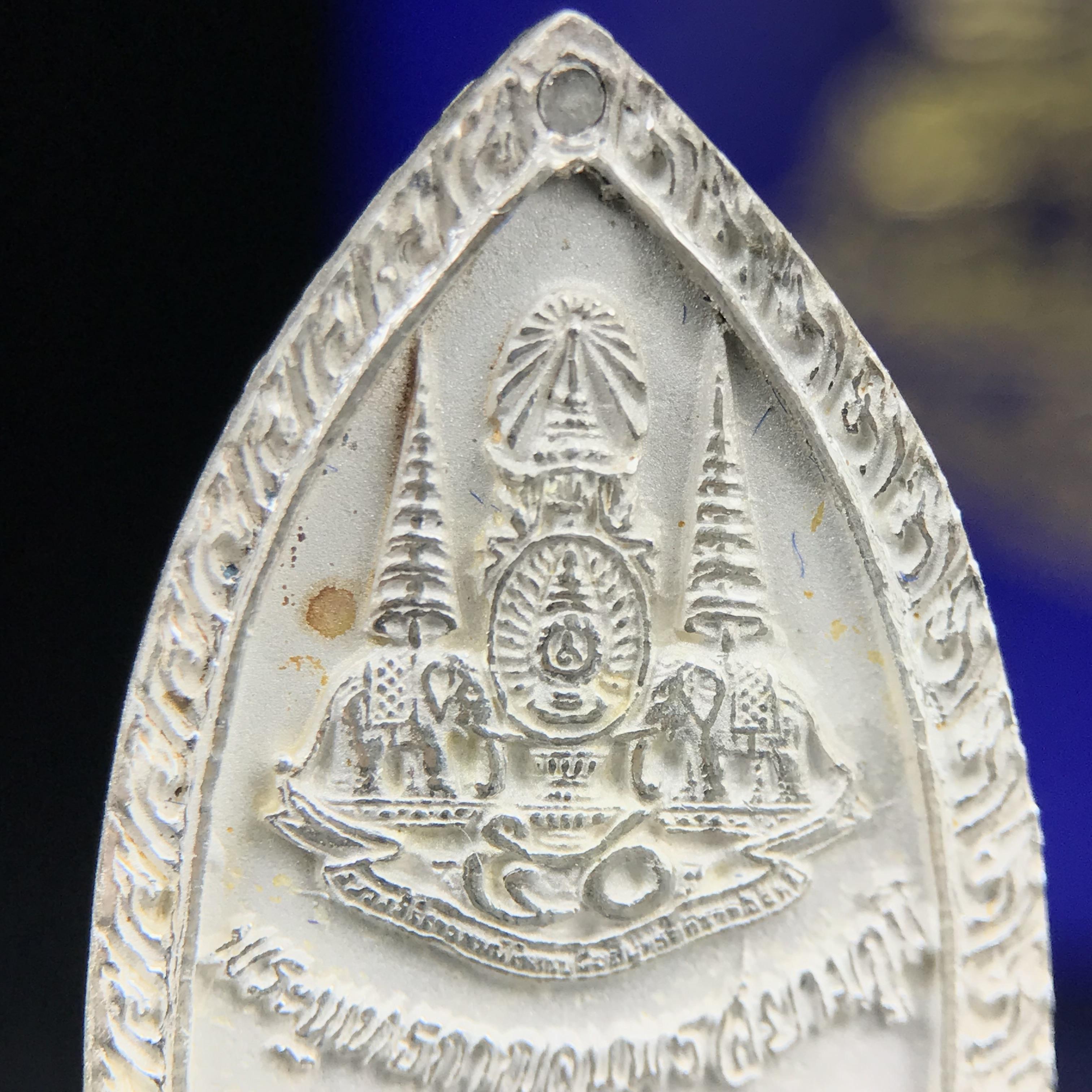 พระพุทธกาญจนพรสยามภูมิ ภปร. ปี 2539 เนื้อเงินพื้นทรายประกาย(ผิวเดิมสวย) พิมพ์ทรงใบขนุน ขนาด3.2ซม. พระพุทธรูปประจำพระชนมวาร รัชกาลที่9 ทรงโปรดเกล้าให้วิทยาลัยป้องกันราชอาณาจักร(วปอ.)สร้างในวโรกาสทรงครองสิริราชสมบัติครบ50ปี พ.ศ.2539(1ใน5000องค์)