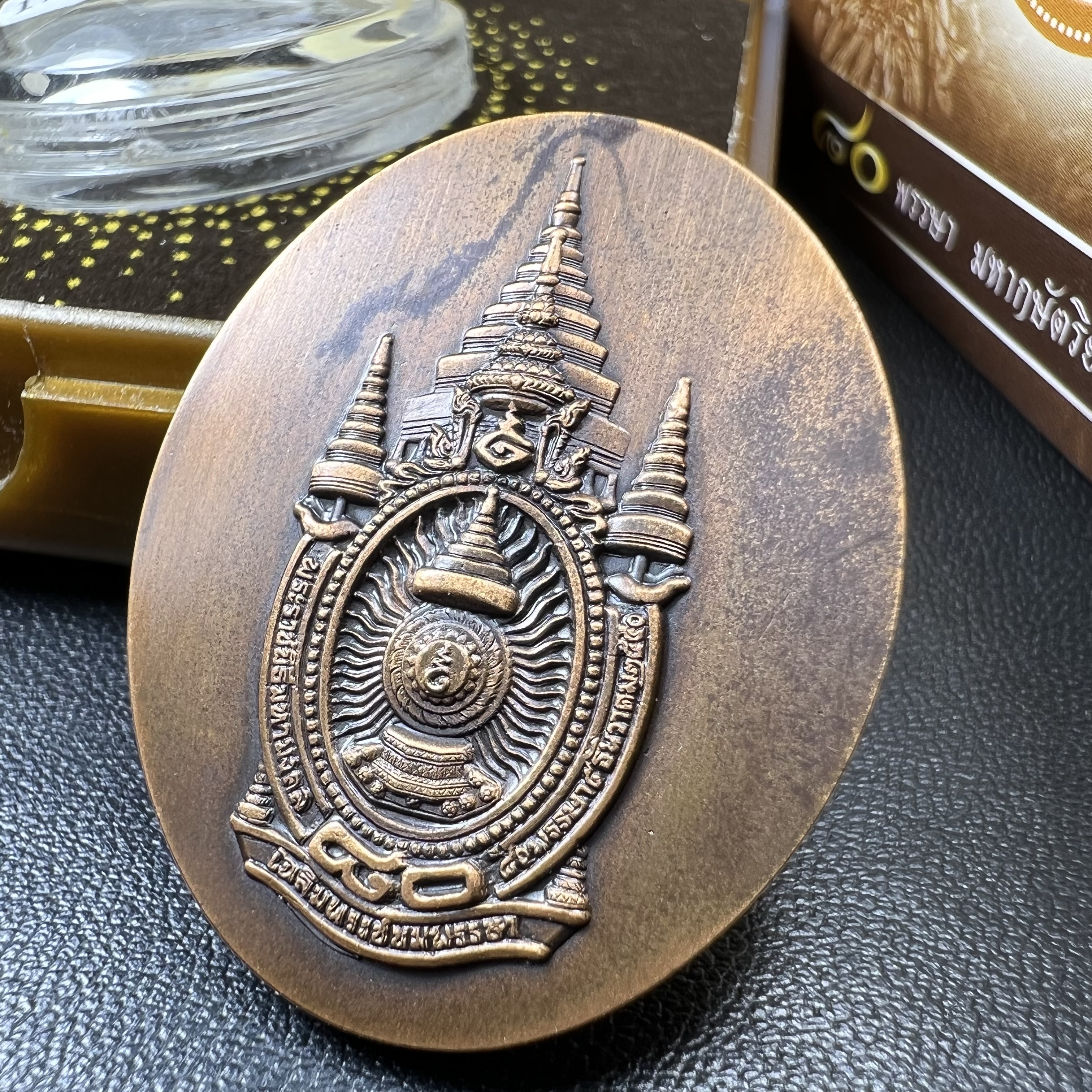 เหรียญรูปหล่อพระบาทสมเด็จพระเจ้าอยู่หัว ในหลวงทรงงาน “รุ่นเย็นศิระเพราะพระบริบาล 80พรรษา มหากษัตริย์คู่แผ่นดินสยาม” พ.ศ.2550 เนื้อทองแดงรมดำ(ขนาด 27*35 มม.)พร้อมกล่องบรรจุเดิมครบ