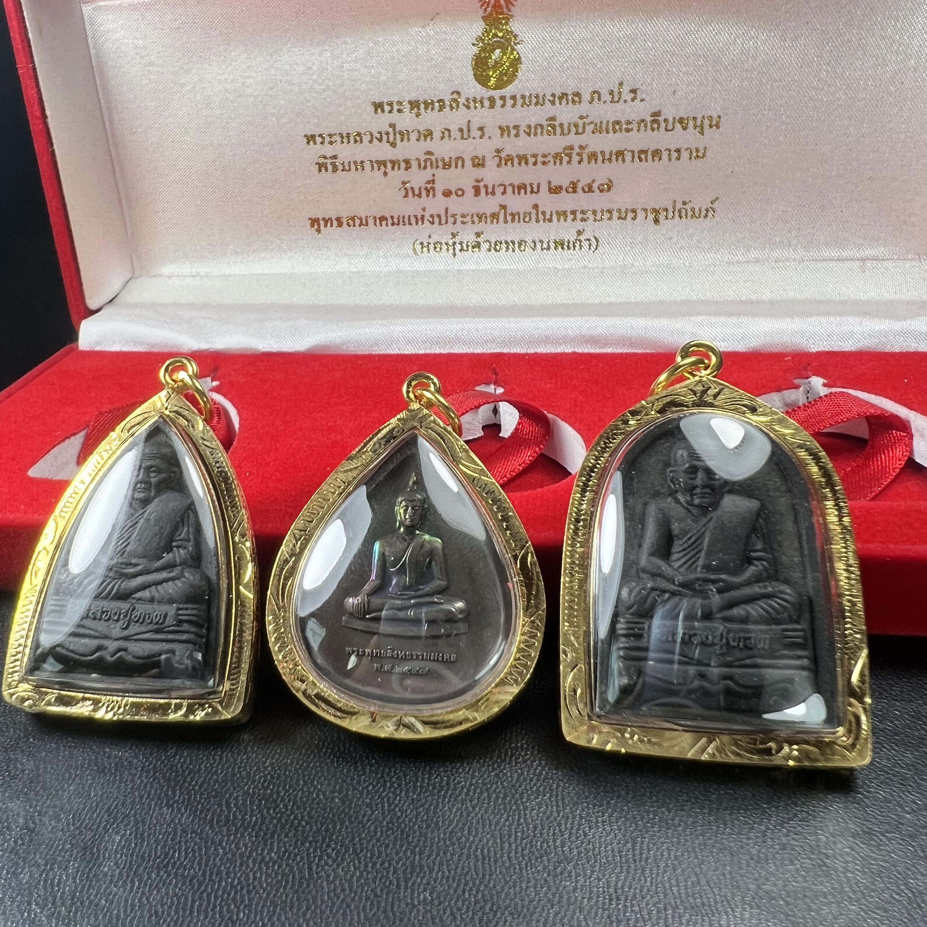 พระชุดของขวัญ 3 องค์ พระหลวงปู่ทวด ภปร. ทรงกลีบบัวและกลีบขนุนพร้อมเหรียญพระพุทธสิงหธรรมมงคล ปี 2547 (ชนวนเก่า)เนื้อว่านด้านหลังมี ภปร. เป็นโลหะผสมสูง 3.3ซม.พิธีใหญ่ มวลสารดี ปลุกเสกวัดพระแก้ว(งานเลี่ยมกรอบเดิมจากผู้จัดสร้างห่อหุ้มด้วยทองนพเกล้า)